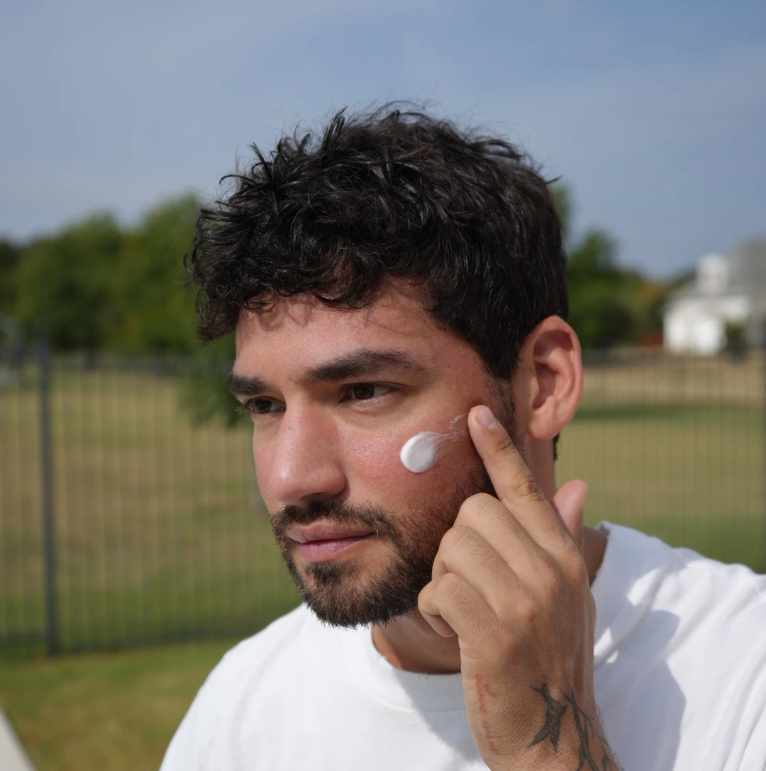 Man applying daily facial hydrator to lock in moisture, smooth skin, and strengthen the skin barrier for a healthy glow.
