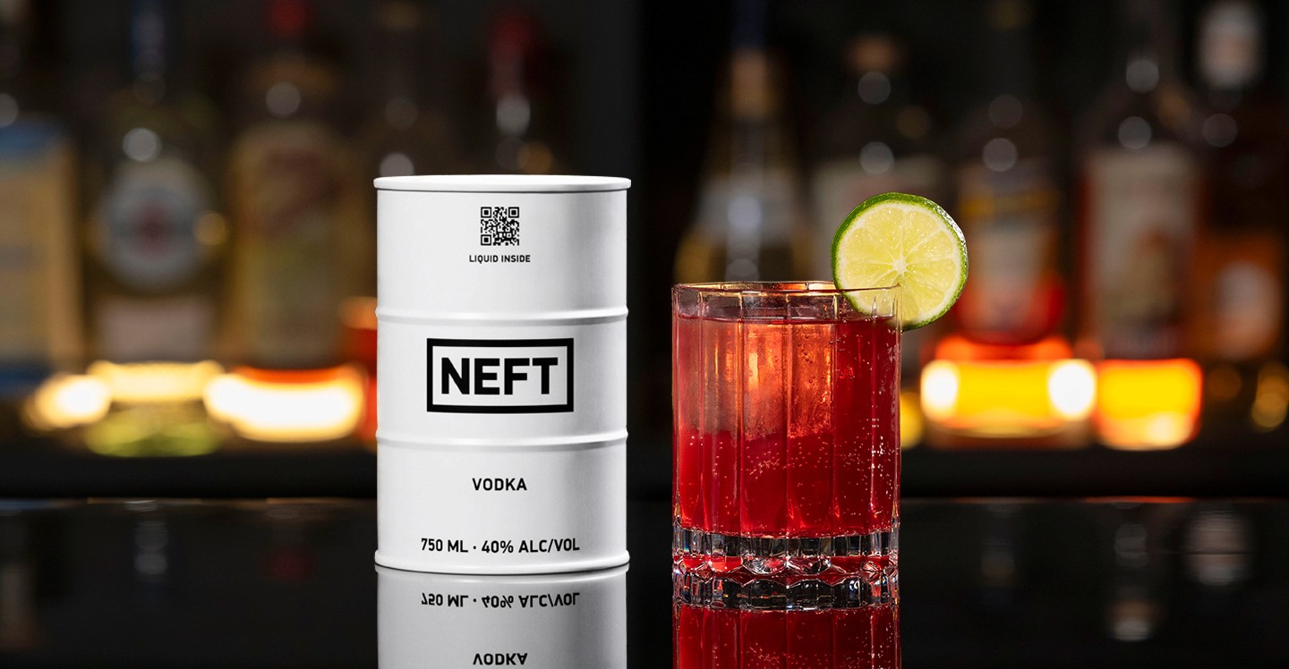A NEFT Barrel and a glass of Pomegranate Mule on a bar counter.