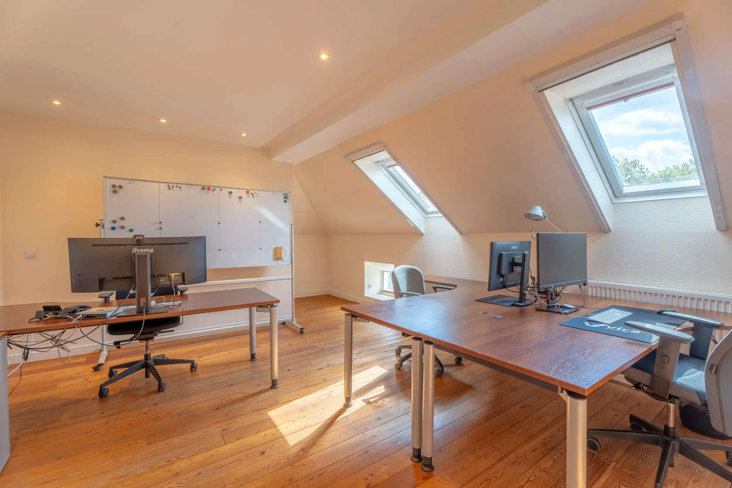 Büroraum unter der Dachschräge der Bürovilla Gronau (Westfalen) mit Doppelarbeitsplatz und Dachfenstern