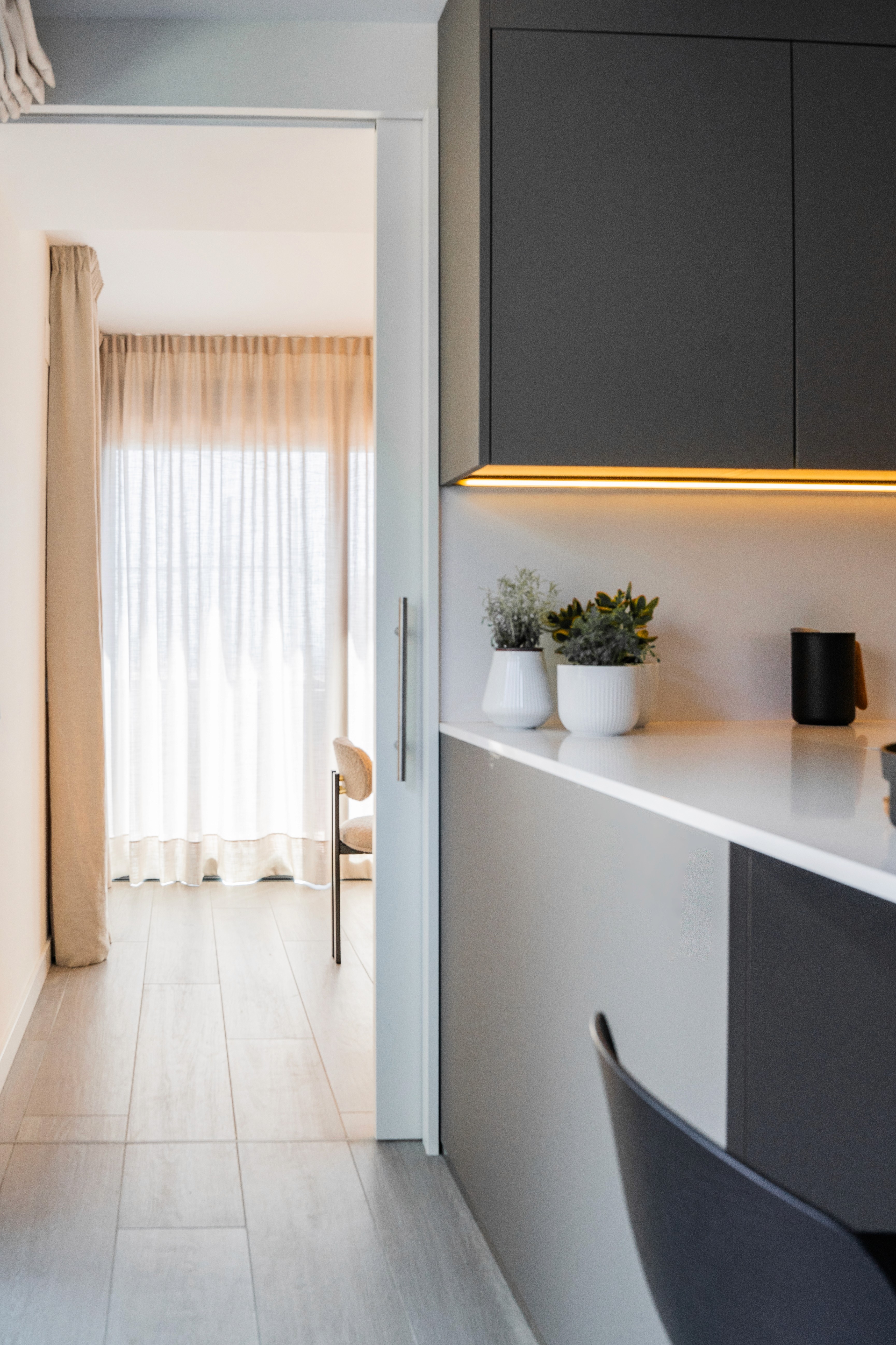 Detalle cocina con muebles gris oscuro y encimera blanca