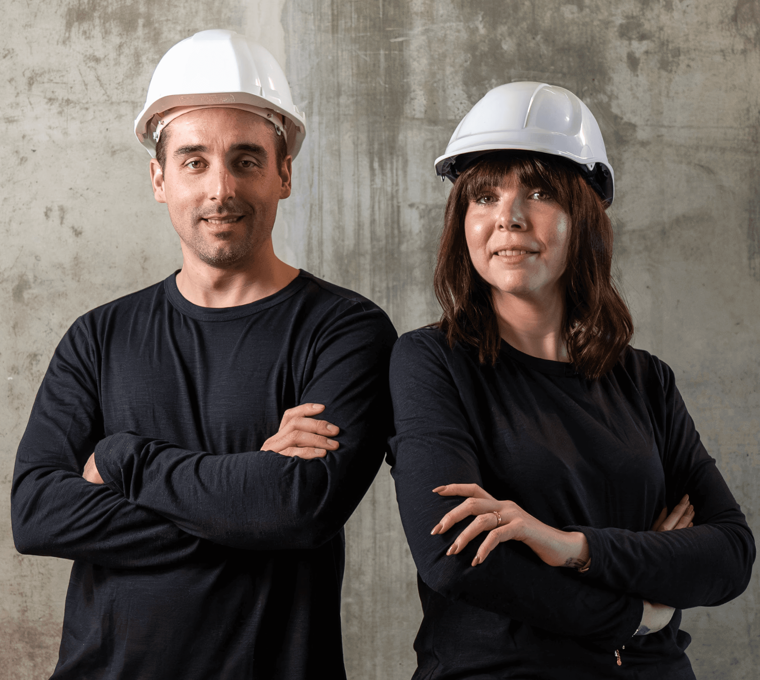 A serene outdoor seating area with two chairs, surrounded by lush greenery and a glassed-in structure.