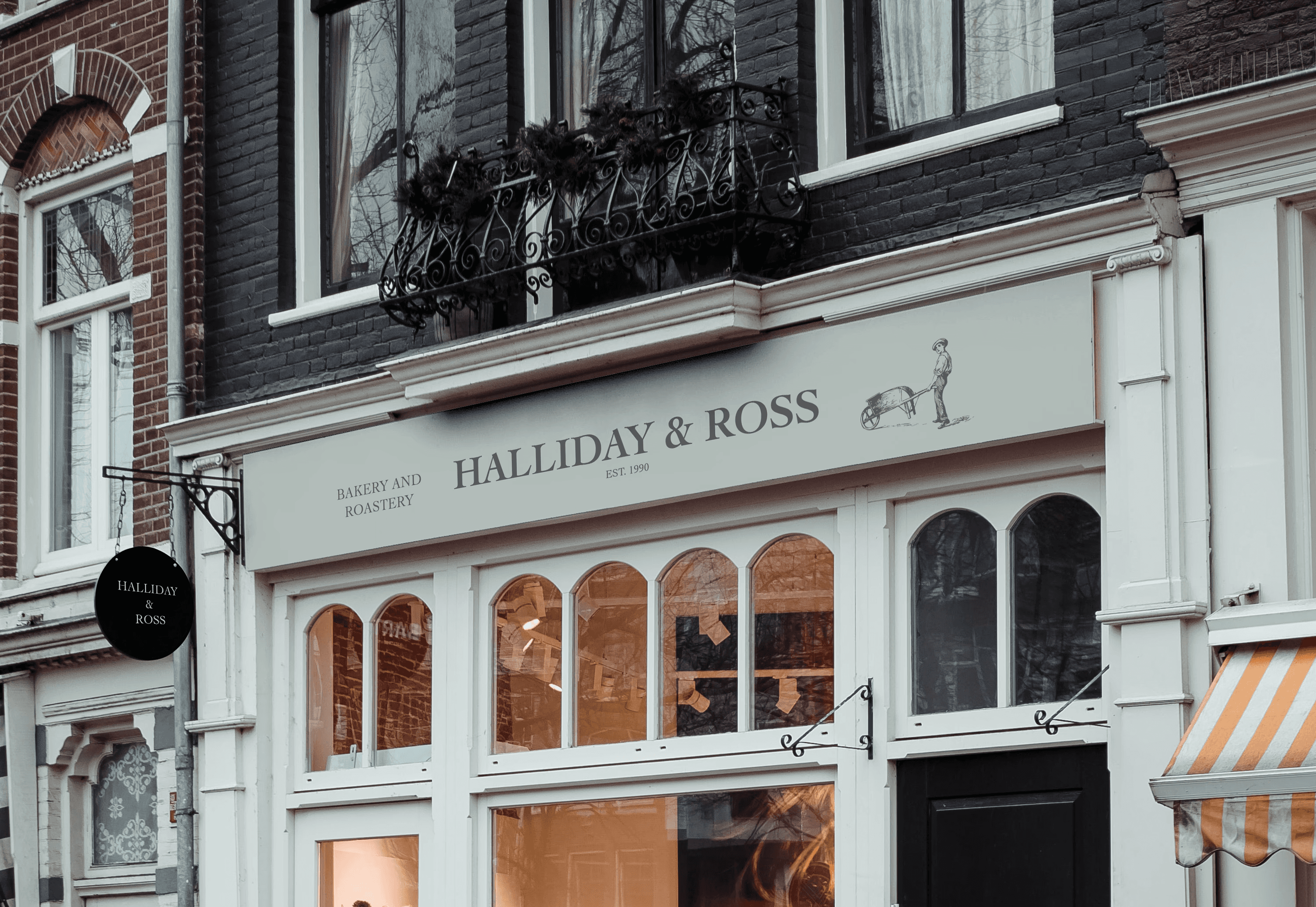 Bakery banner design for Halliday and Ross, a bakery and roastery in London. Design features text and a sleek, well-drawn image of a boy pushing a wheelbarrow