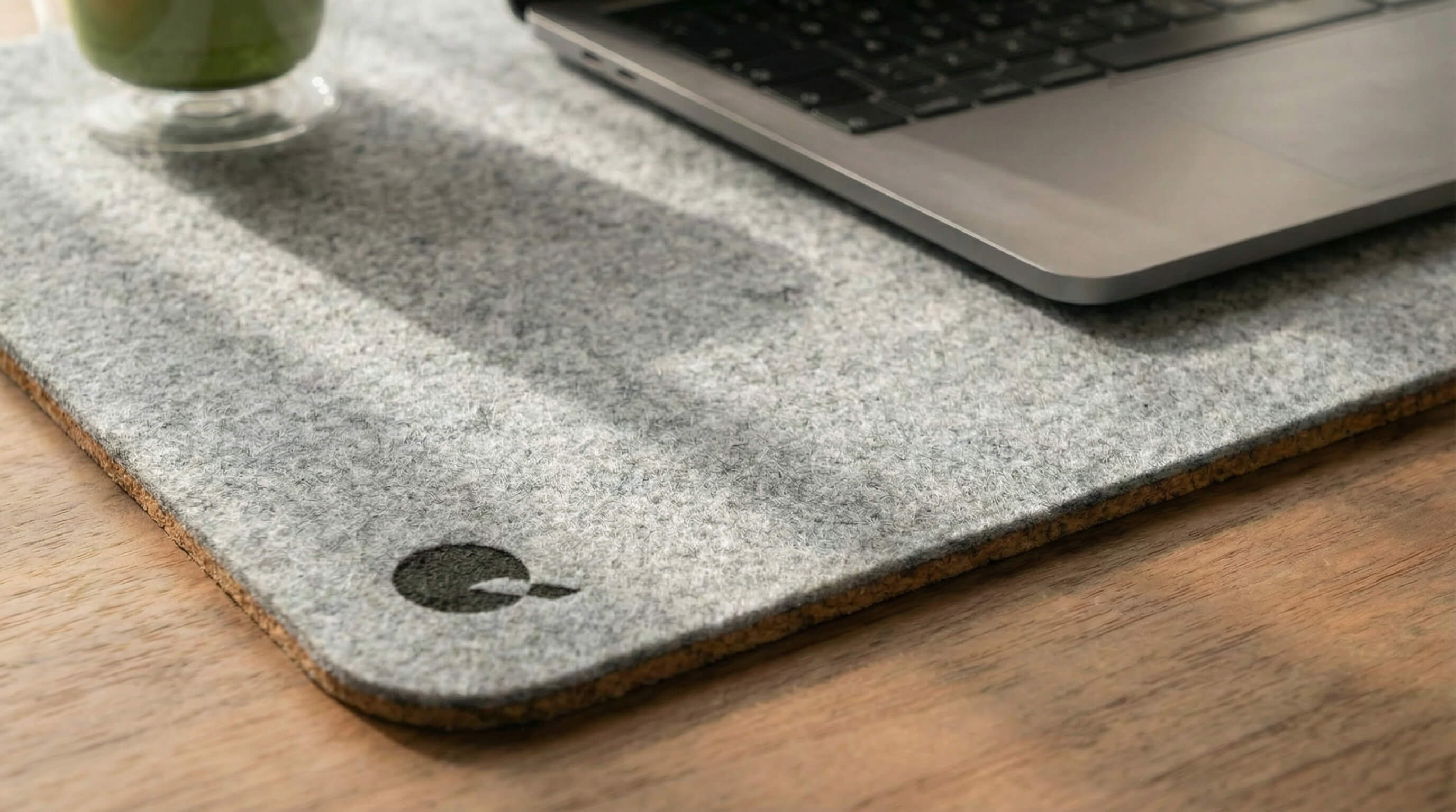 Close-up of light grey felt desk mat showing high-density cork base