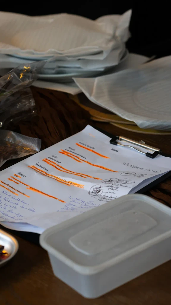 The printed tasting menu on a clipboard with plating sketches