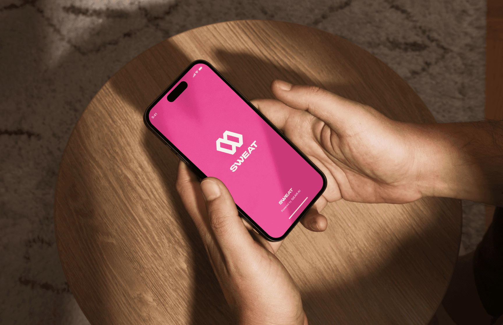 Image depicting a person holding a phone that has Sweat Wallet installed on the device.