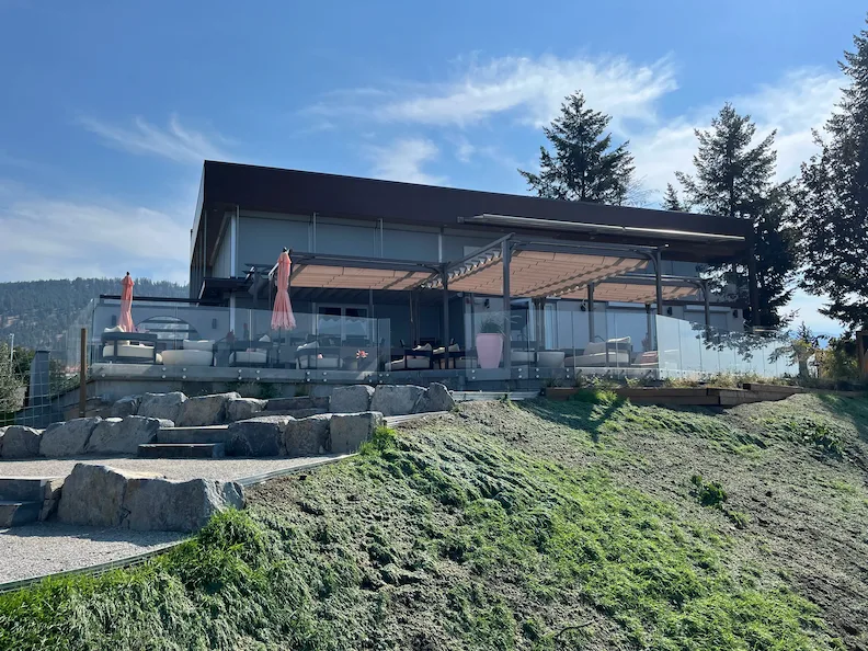 Frameless glass railing surrounding a modern patio with pergola, showing clear views and contemporary outdoor design in Burnaby, BC.