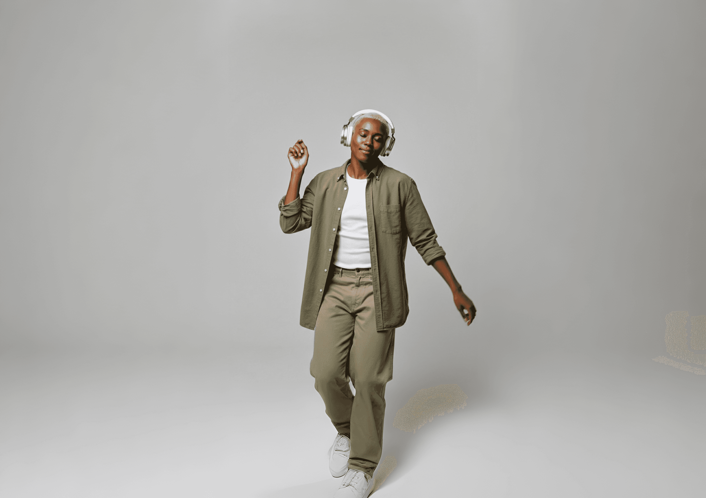 Man wearing silver headphones listening to music and dancing.