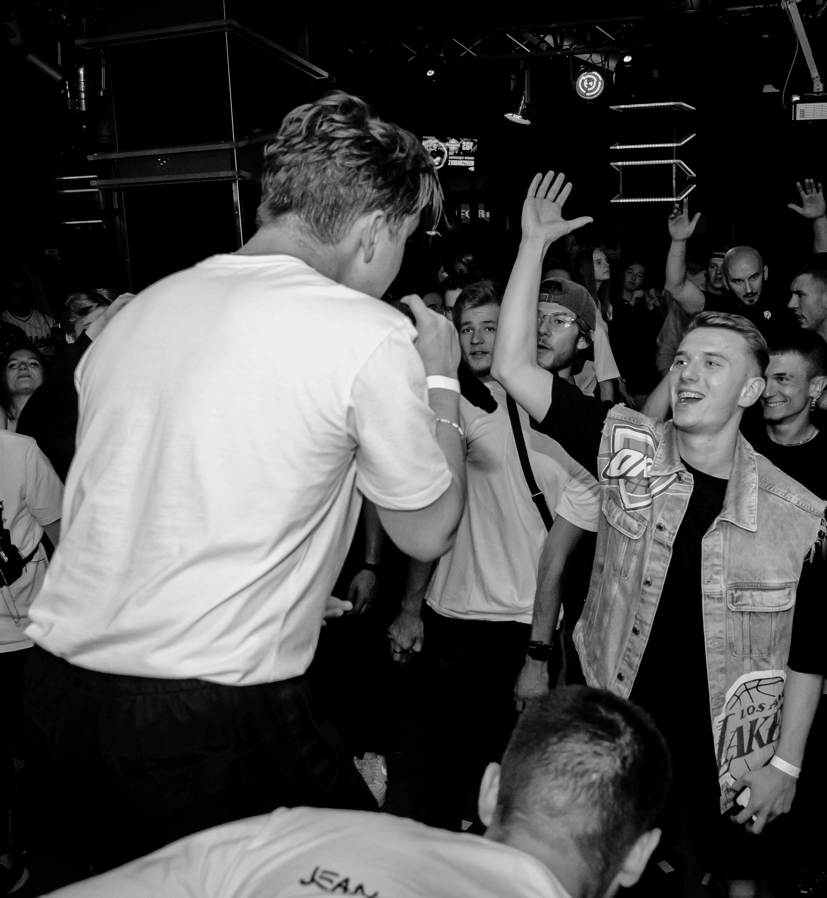 Close up photo from behind the back of Bartek from the concert he played at with Blessed Family. Bartek is back to the camera on the left and on the right we can see the crowd.