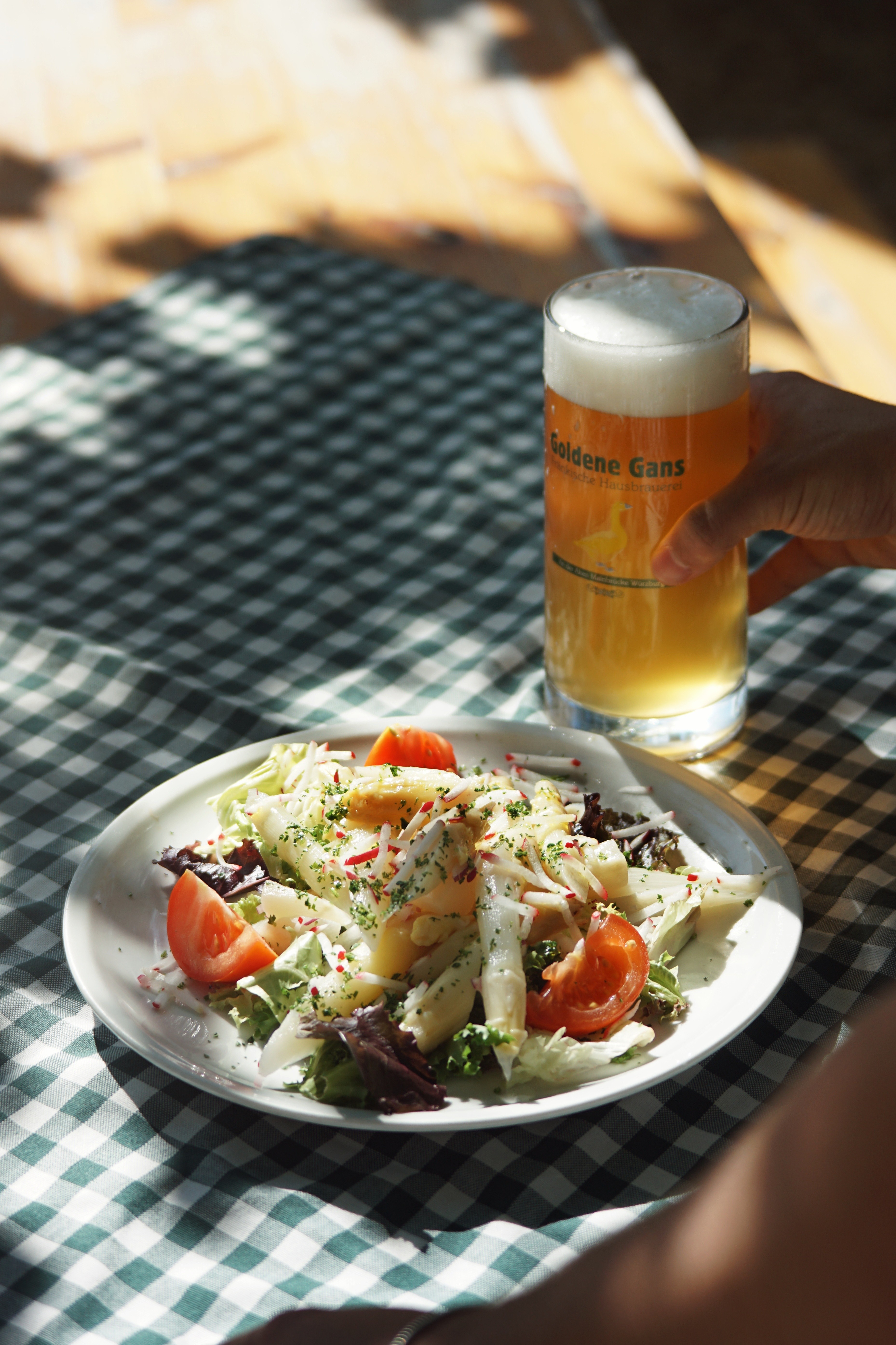 Slat mit Tomaten und Spargel, daneben ein Bierglas mit "Goldene Gans" Logo