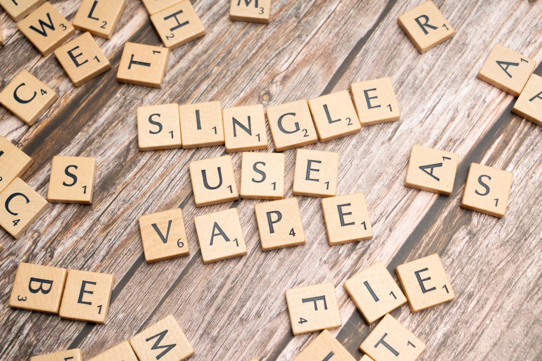 scrabble tiles spelling the word single use vape on a wooden surface