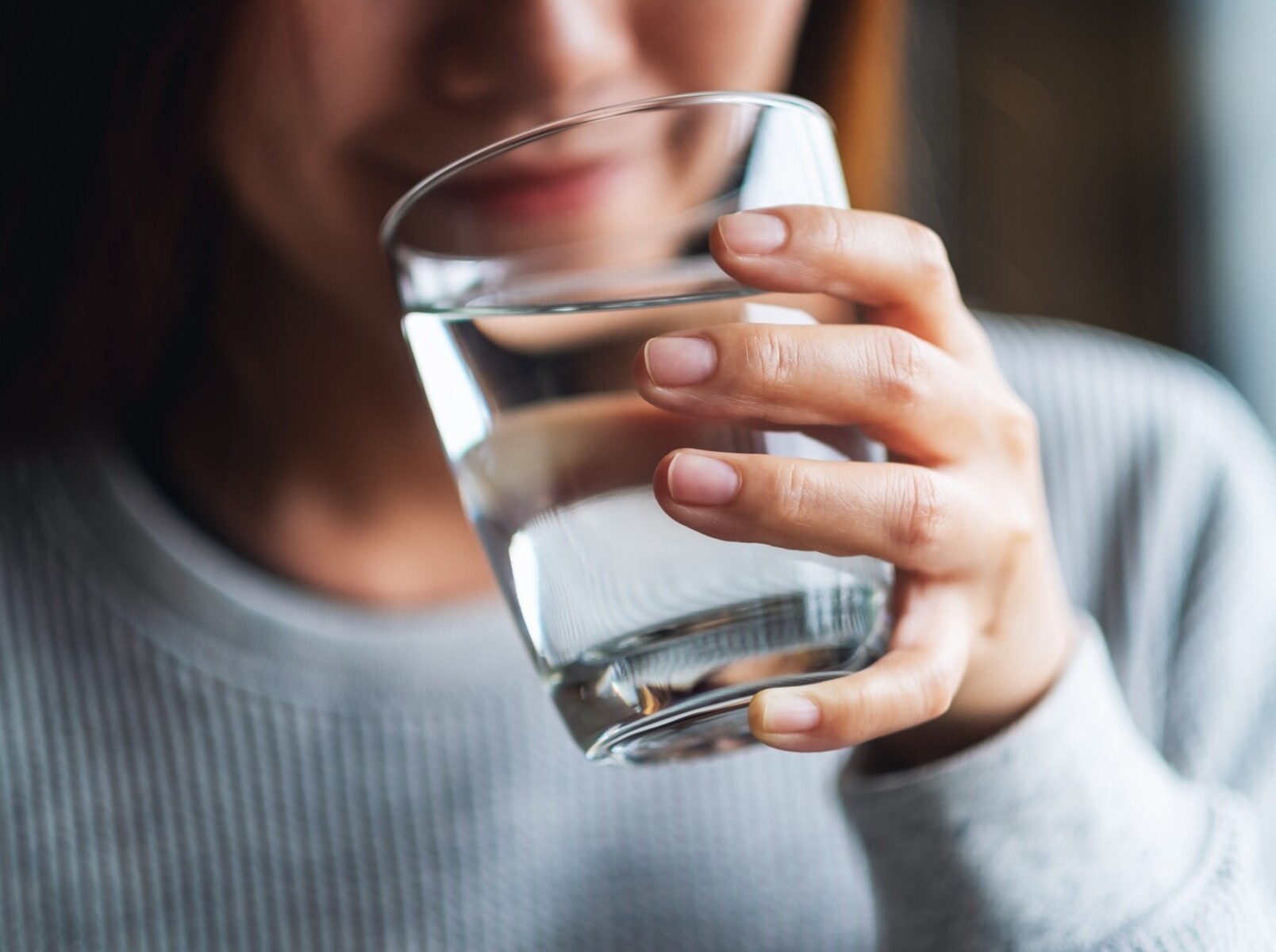 woman drinking a glass of water after doing her Epsom salt bath water weight loss routine
