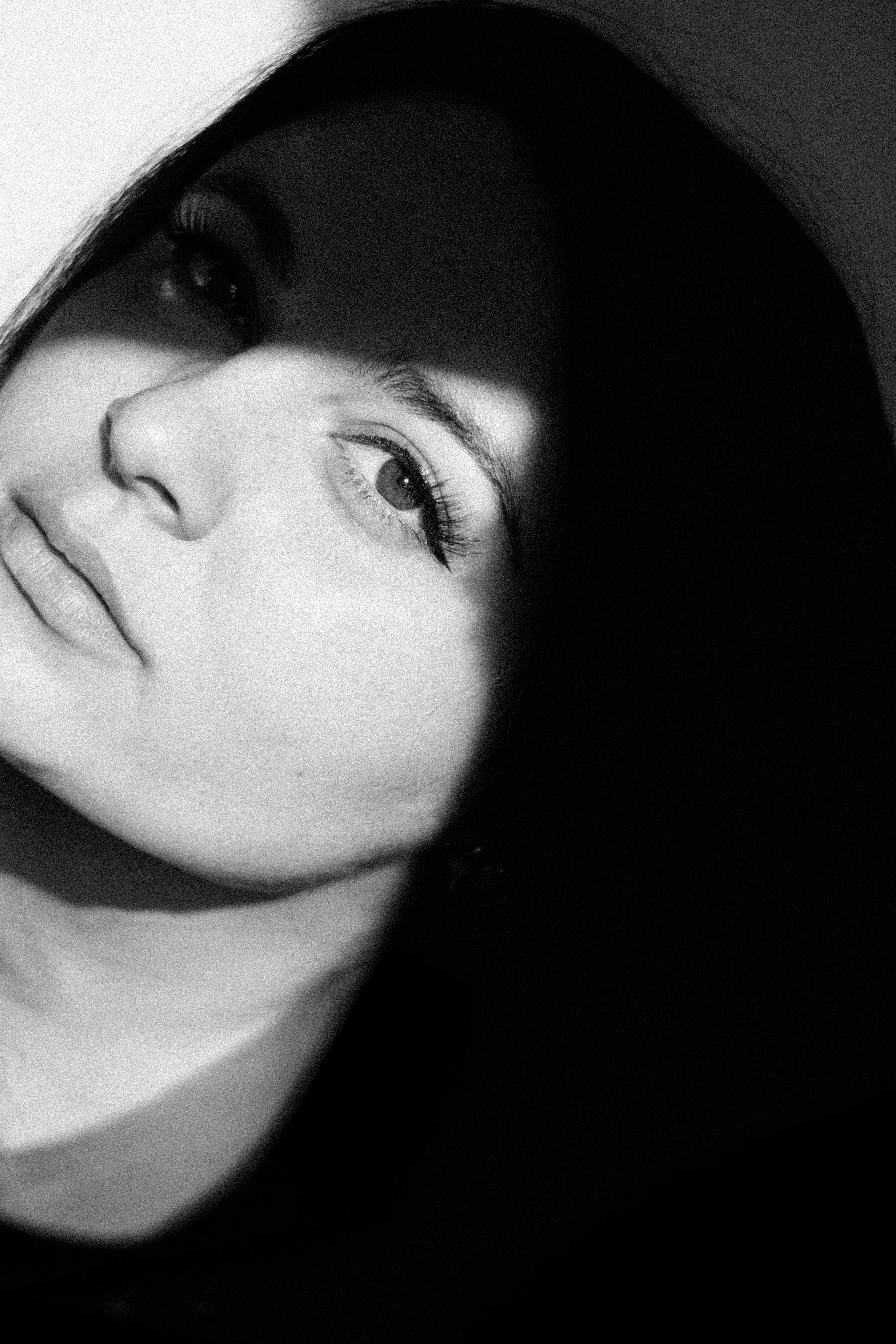 Black and white portrait of a woman with dramatic lighting.