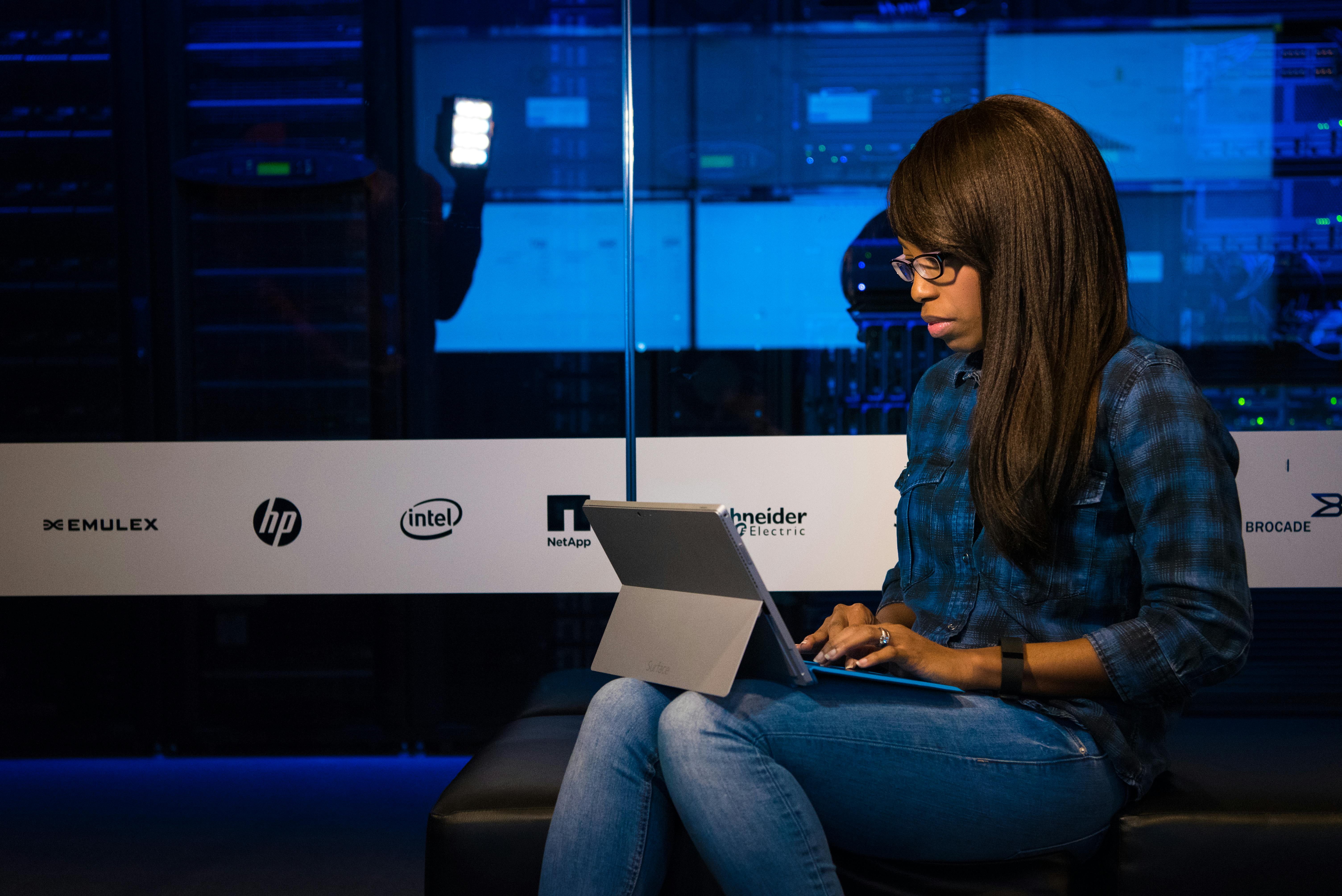person typing on MacBook Pro on brown wooden table during daytime photo