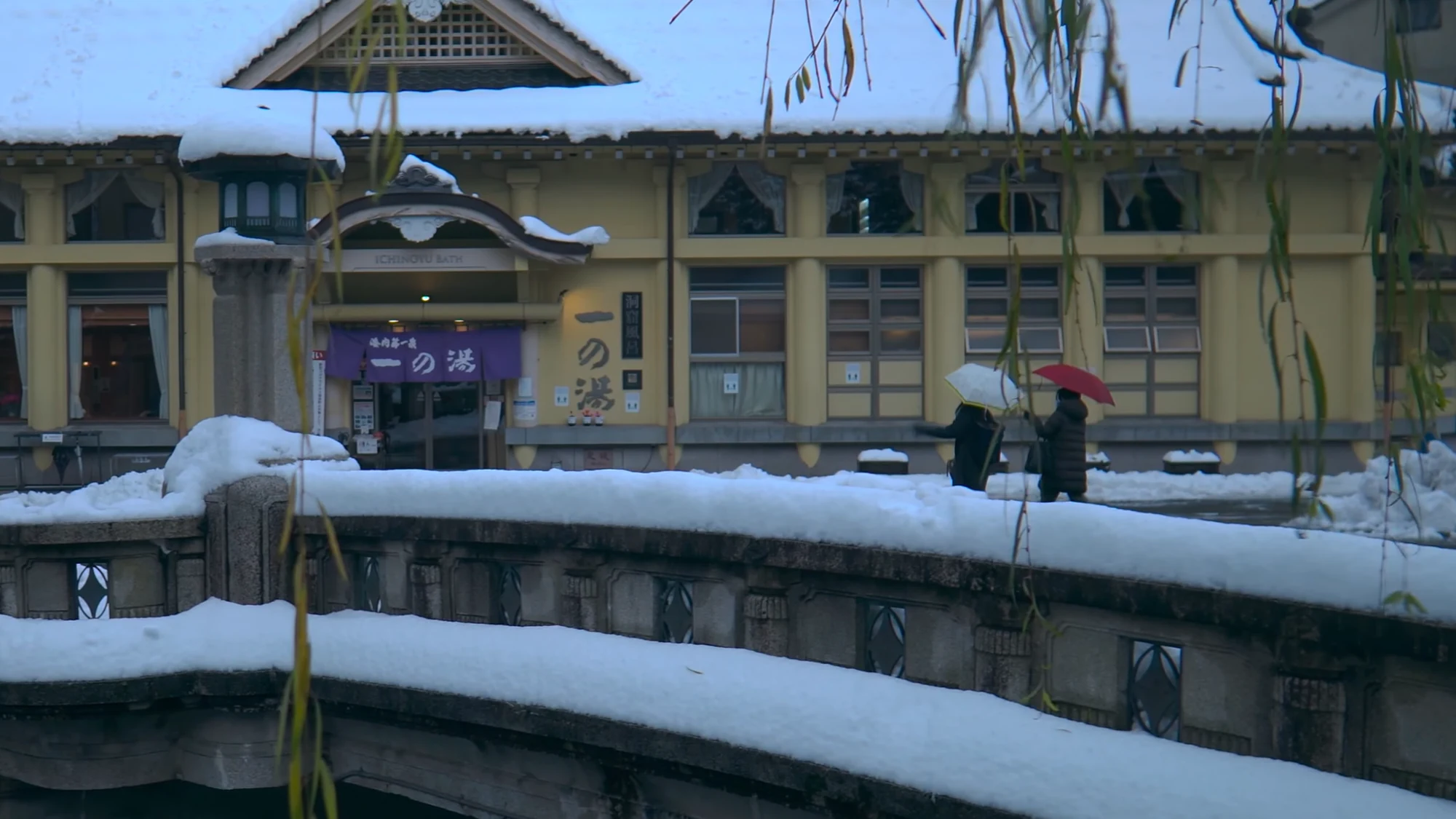 Ichi-no-yu bathhouse in Kinosaki under snow with the canal in the foreground.