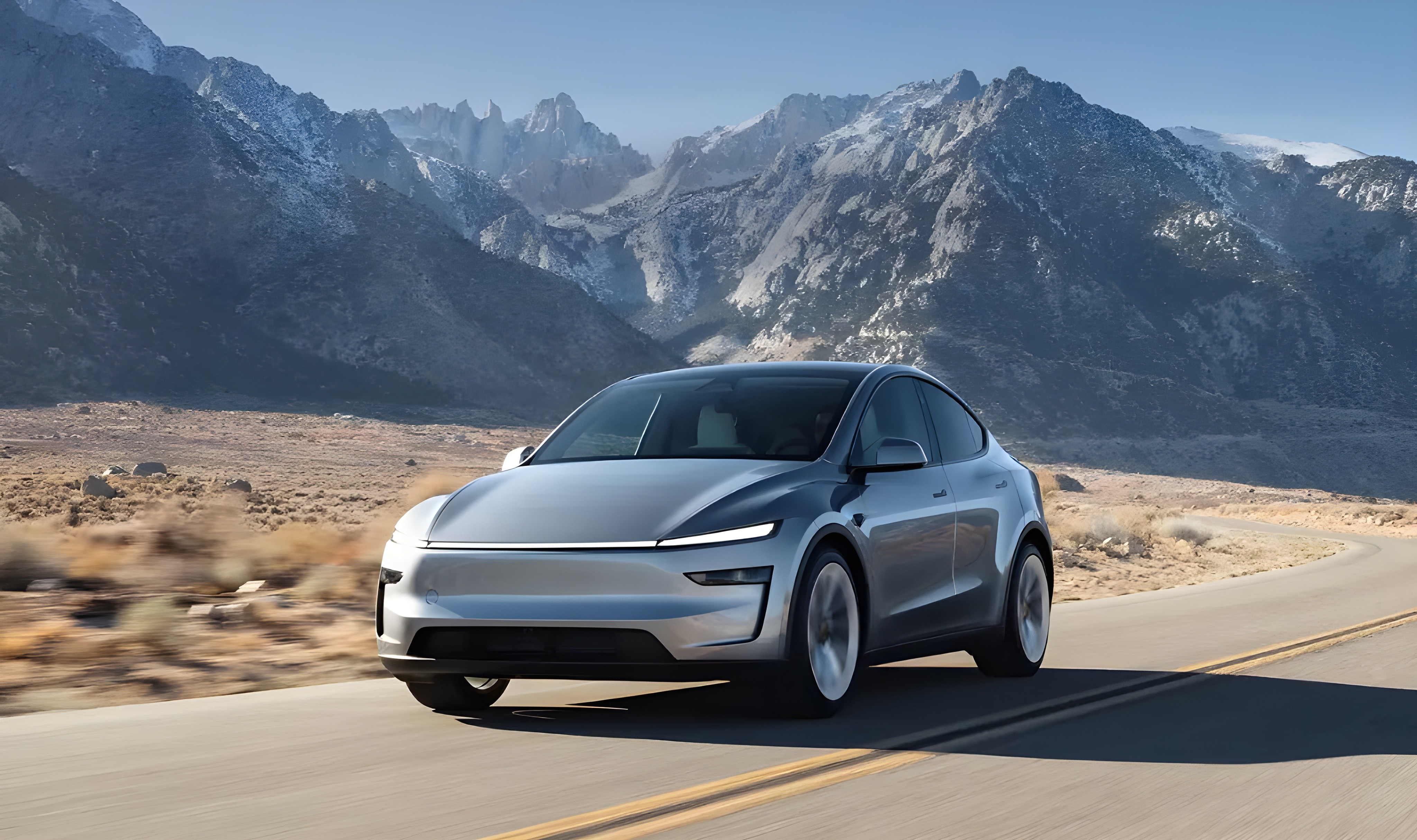 Tesla Model Y 2025 sur route panoramique, SUV électrique vu de face dans un décor montagneux