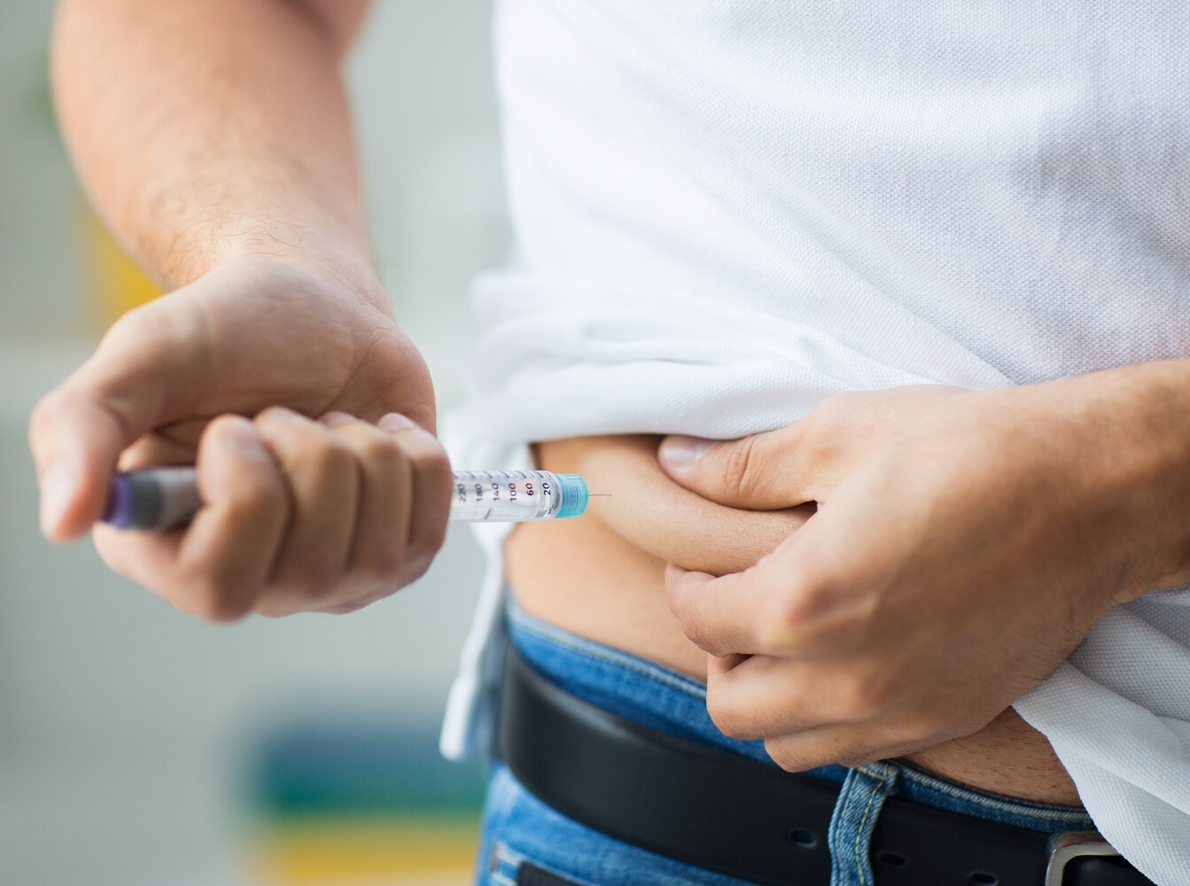man giving himself an insulin shot instead of using diabetes weight loss drugs as a treatment for type 1 diabetes