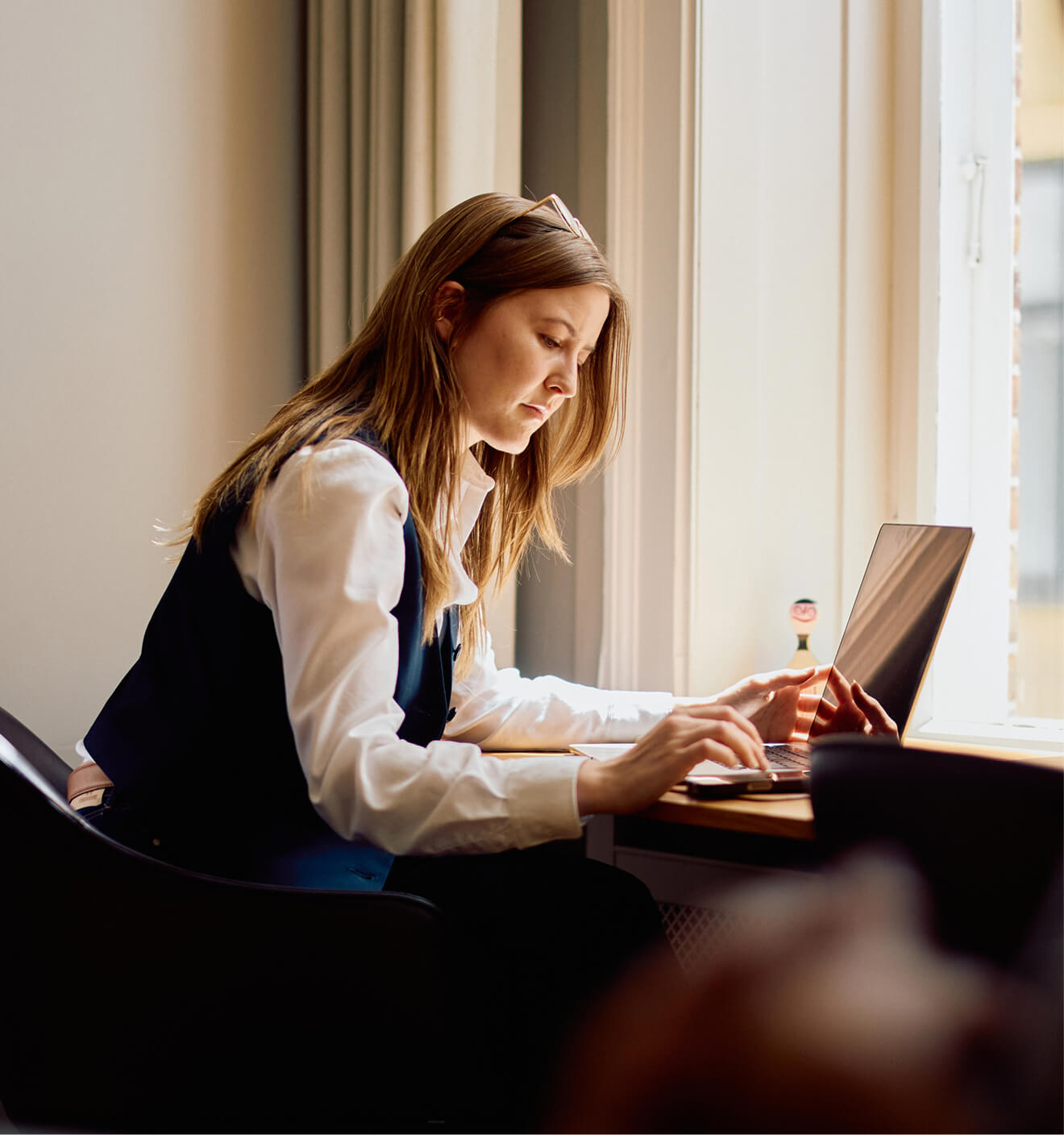 woman working at desk with a laptop