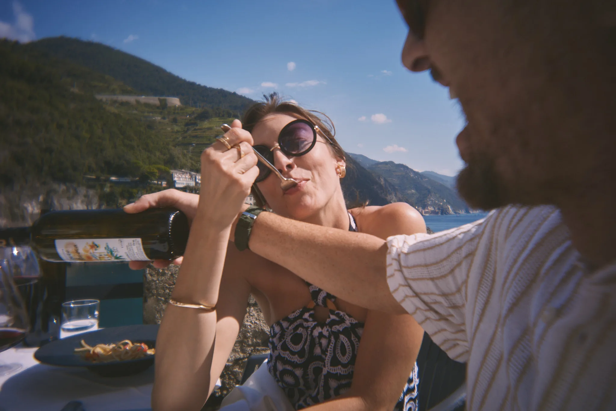 woman tastes fork bite at coastal lunch — lifestyle photography by Tom Kubik
