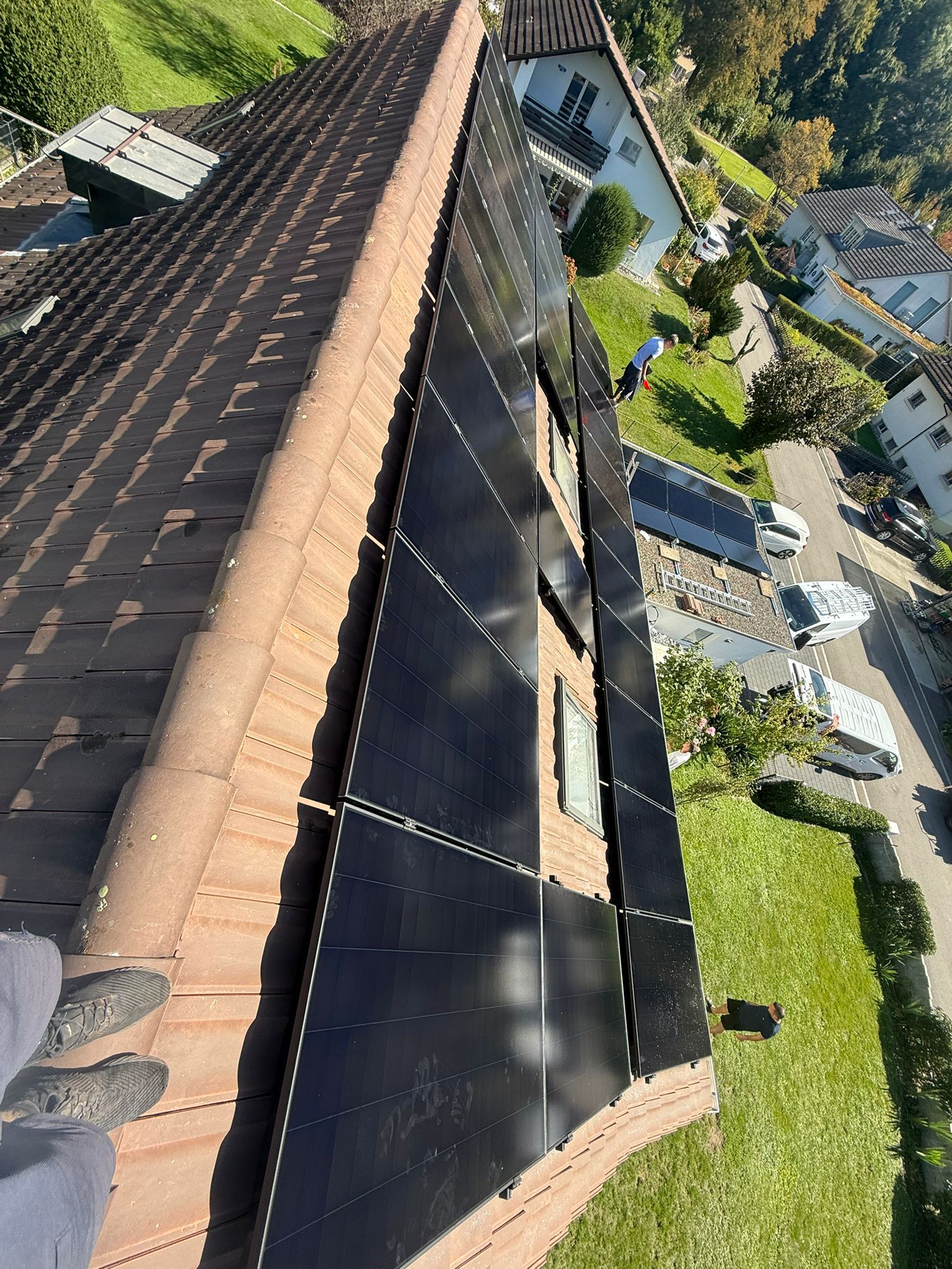 Nahaufnahme der Modulreihen einer 19 kWh Anlage auf einem Ziegeldach in Wildegg aus der Sicht eines Monteurs.