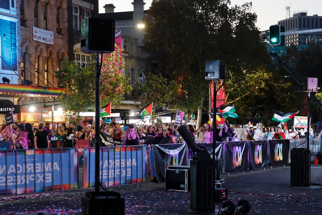 Crowd gathered at a street event with flags and speakers