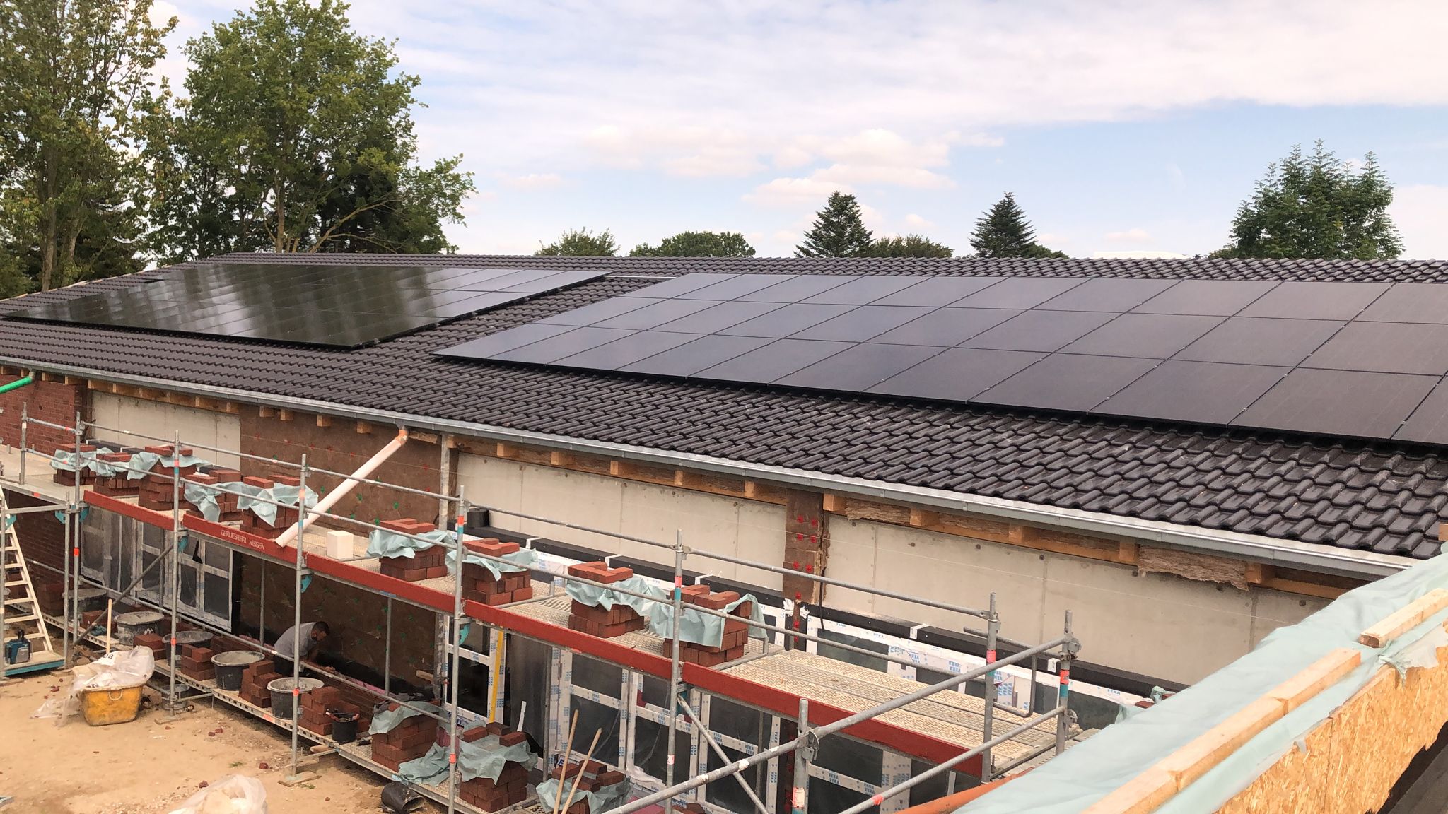brown brick house with solar panels on roof