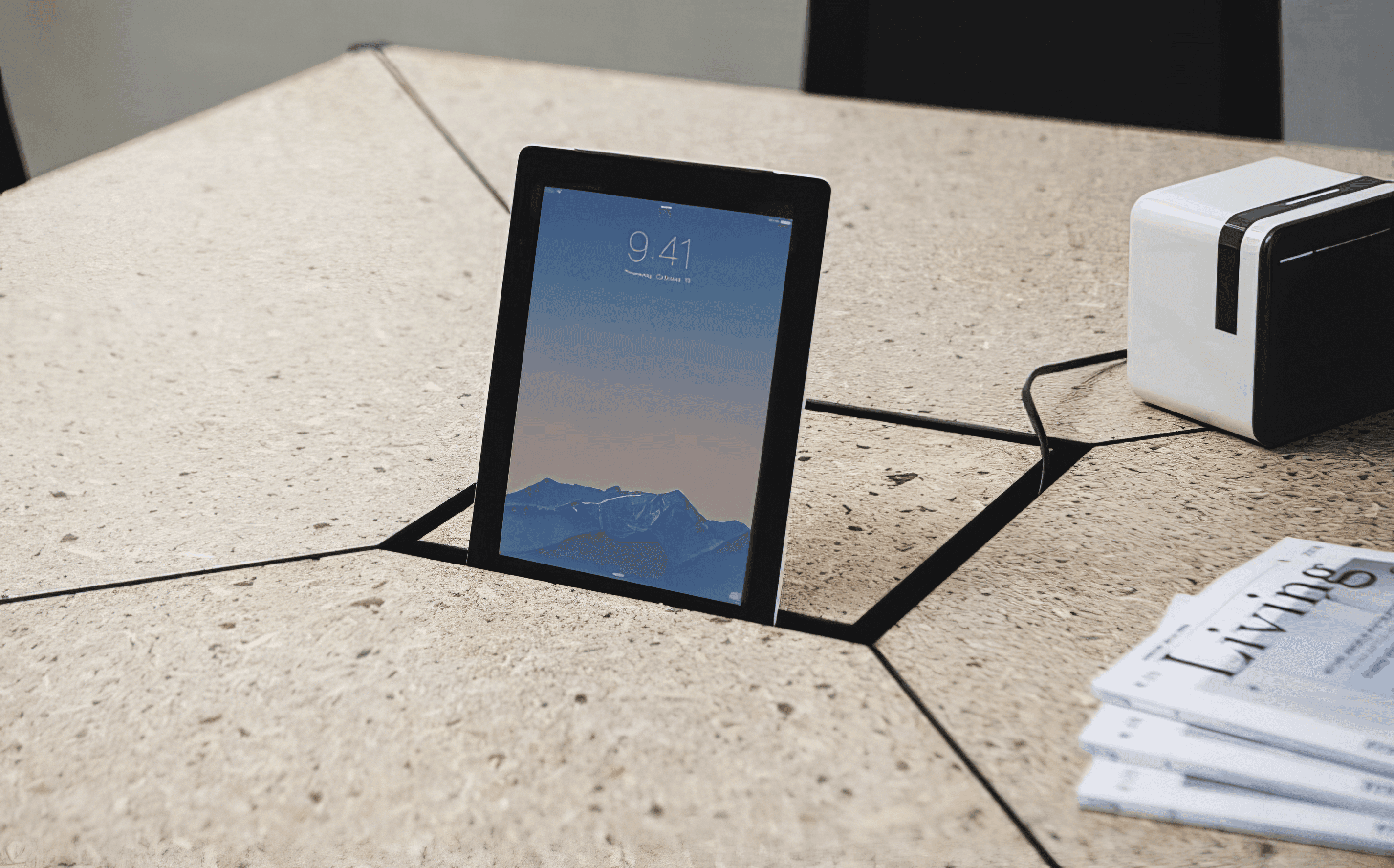MW Interior  - Detailaufnahme einer Tischoberfläche in Terrazzo-Optik mit eingelassener Tablet-Halterung und Kabelführung" Beschreibung: Detailansicht einer hochwertigen Tischplatte in Terrazzo-Optik mit präzise eingefrästem Kabelkanal und integrierter Tablet-Aufnahme – technische Funktionalität und gestalterischer Anspruch in einem.