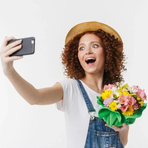 Donna adulta che guarda lo smartphone durante una pausa, simbolo della dipendenza tecnologica negli adulti e della difficoltà a restare presenti con sé stessi.