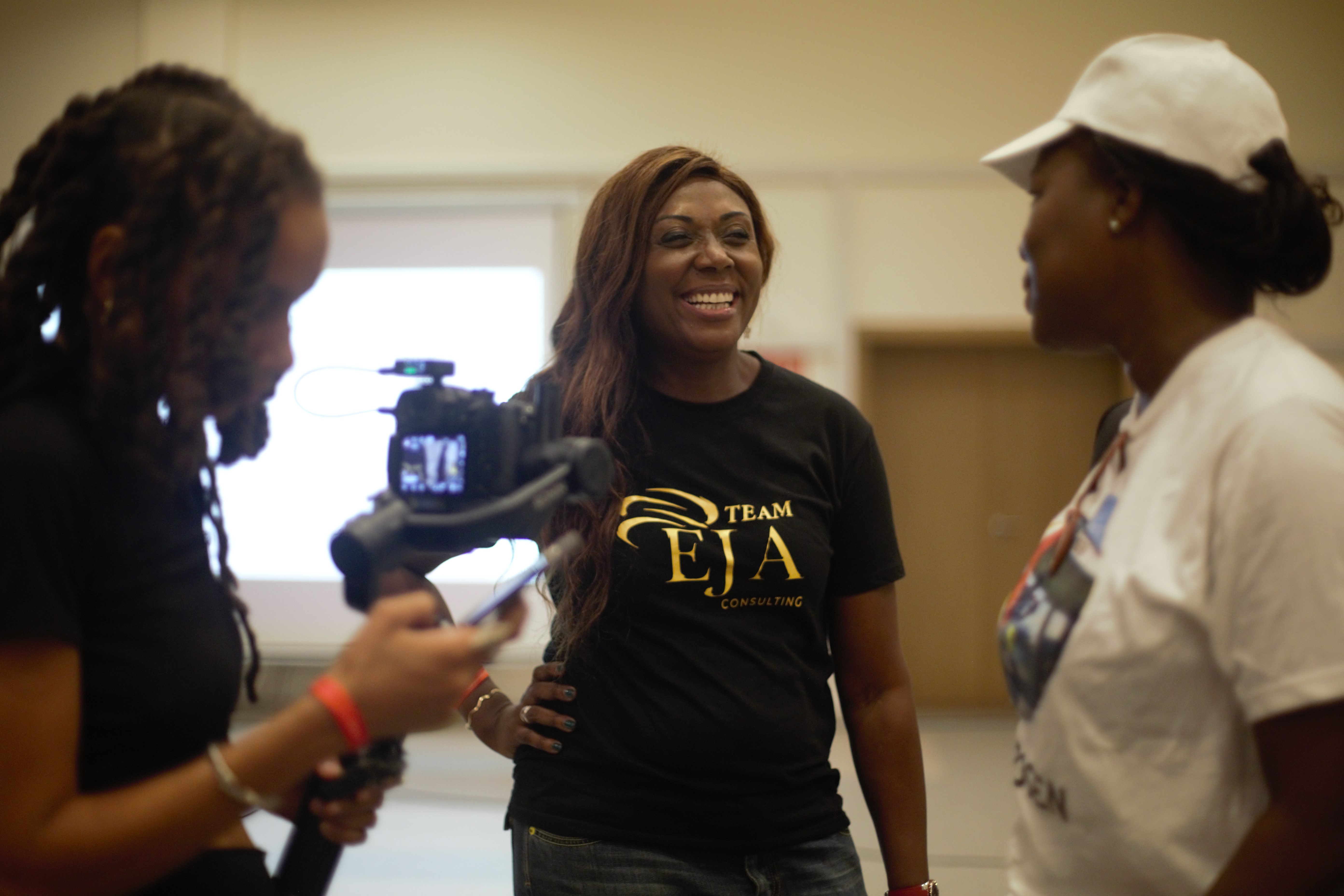 A small white motorboat cruises on turquoise water, leaving a wake, next to a massive, craggy white rock cliff formation under a hazy sky.