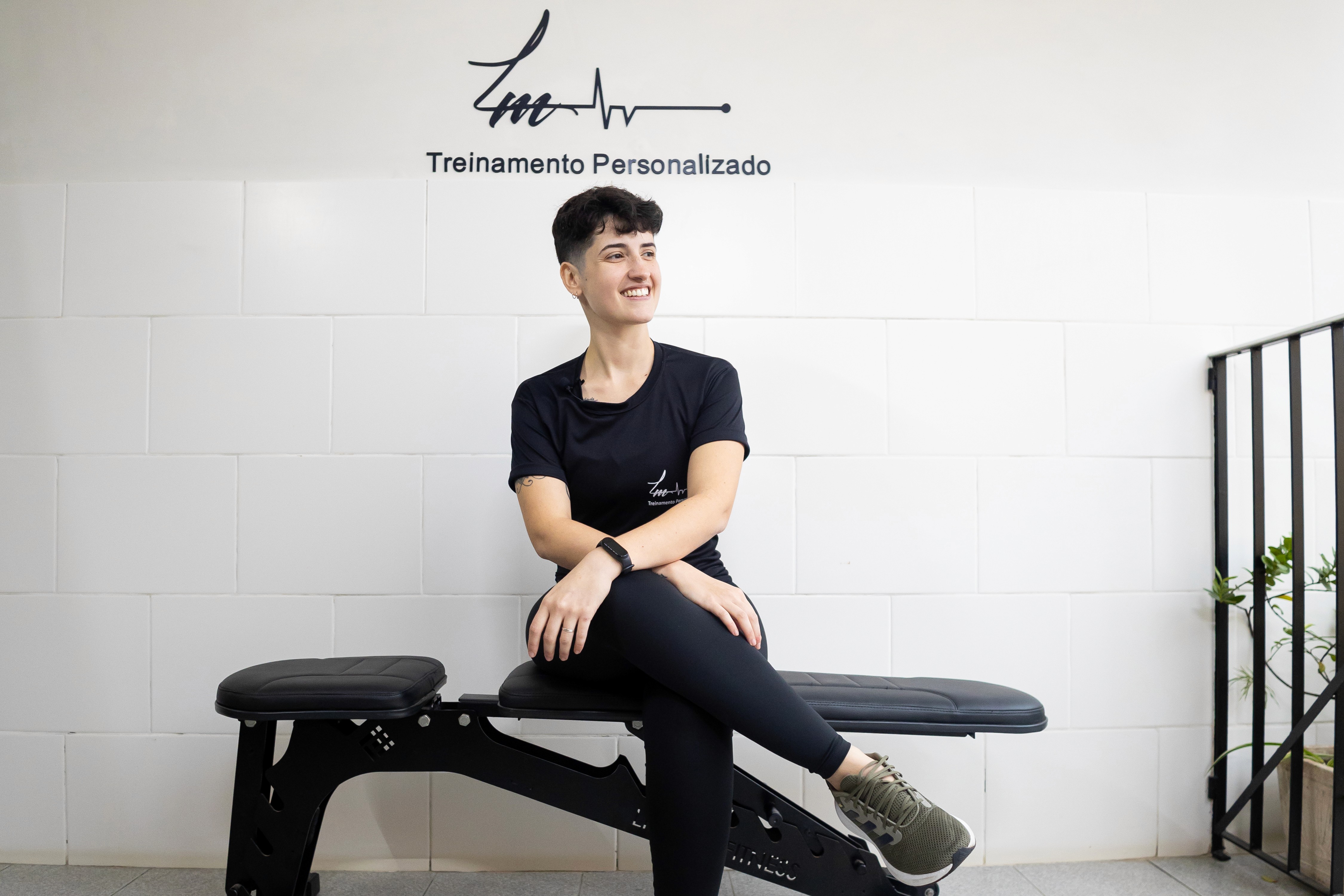 Rachel, personal trainer, looking to the side confidently in a fitness studio