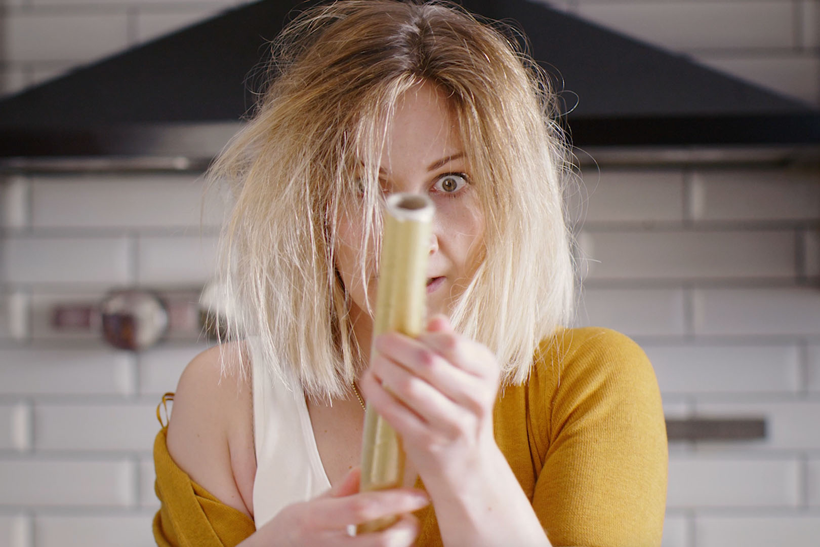 A woman trying to unroll cling film looking very stressed and frustrated