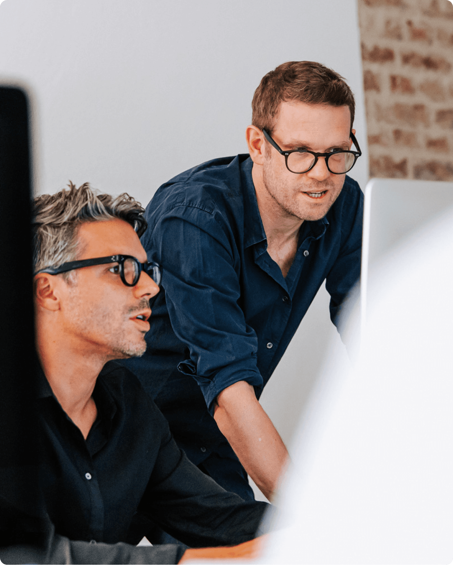 Peter Respondek, Executive Creative Partner, reviewing work with a colleague on a screen during a collaborative session.