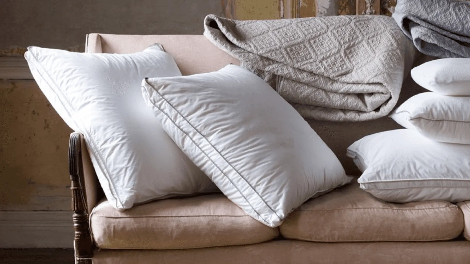 A couch covered in cushions and throws