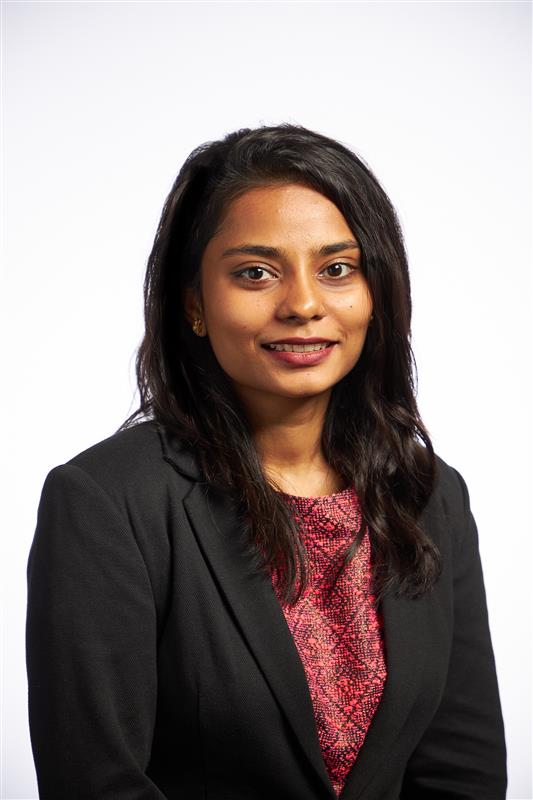 Man with arms crossed in modern office workspace.