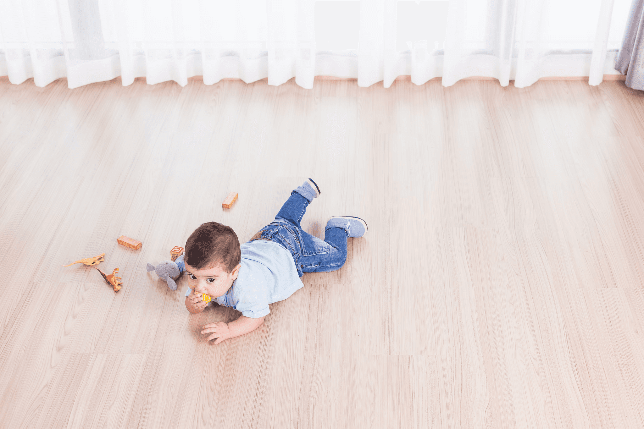 A baby crawling and playing on light wood-look hybrid flooring, highlighting LUXO Floors’ safe, hypoallergenic, and family-friendly hybrid floors ideal for healthy Australian homes.