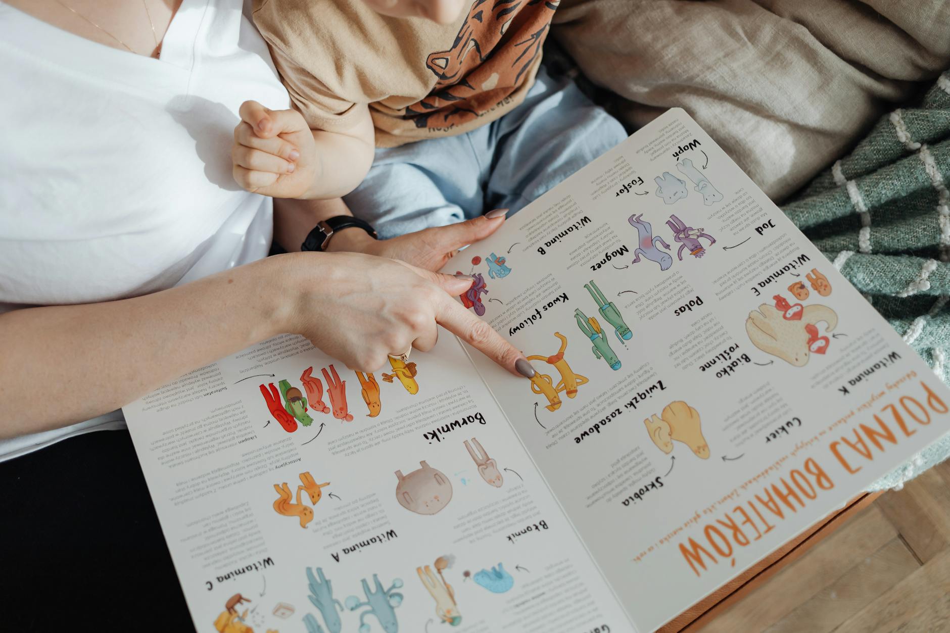 A toddler sitting on a soft rug, eagerly pointing at colorful illustrations in sturdy books for 2 year olds.