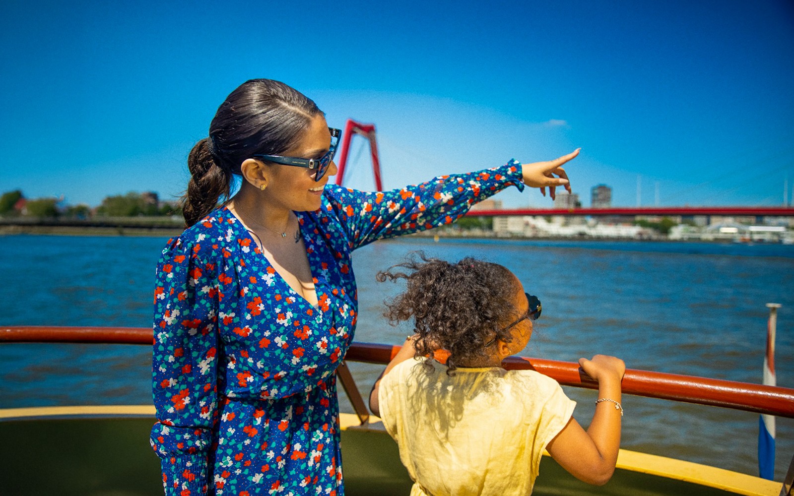 Guests enjoying the view from the Pancake Cruise in Rotterdam, with a bridge in the background.