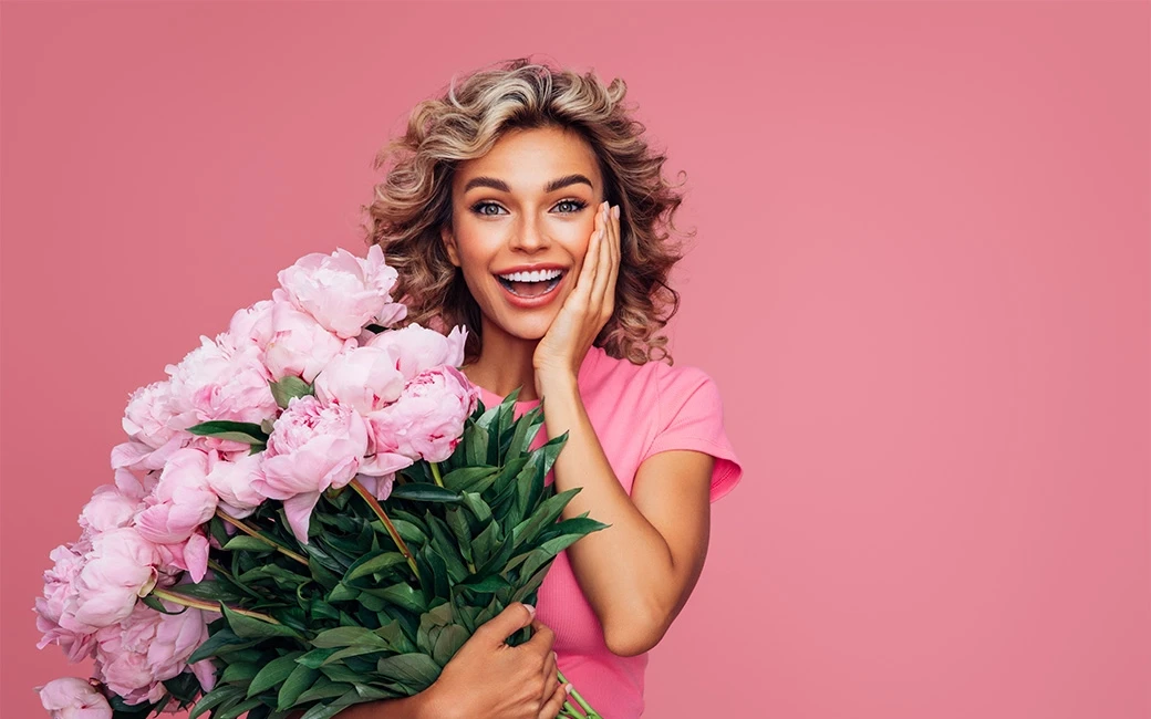 Vrouw met een grote bos roze bloemen
