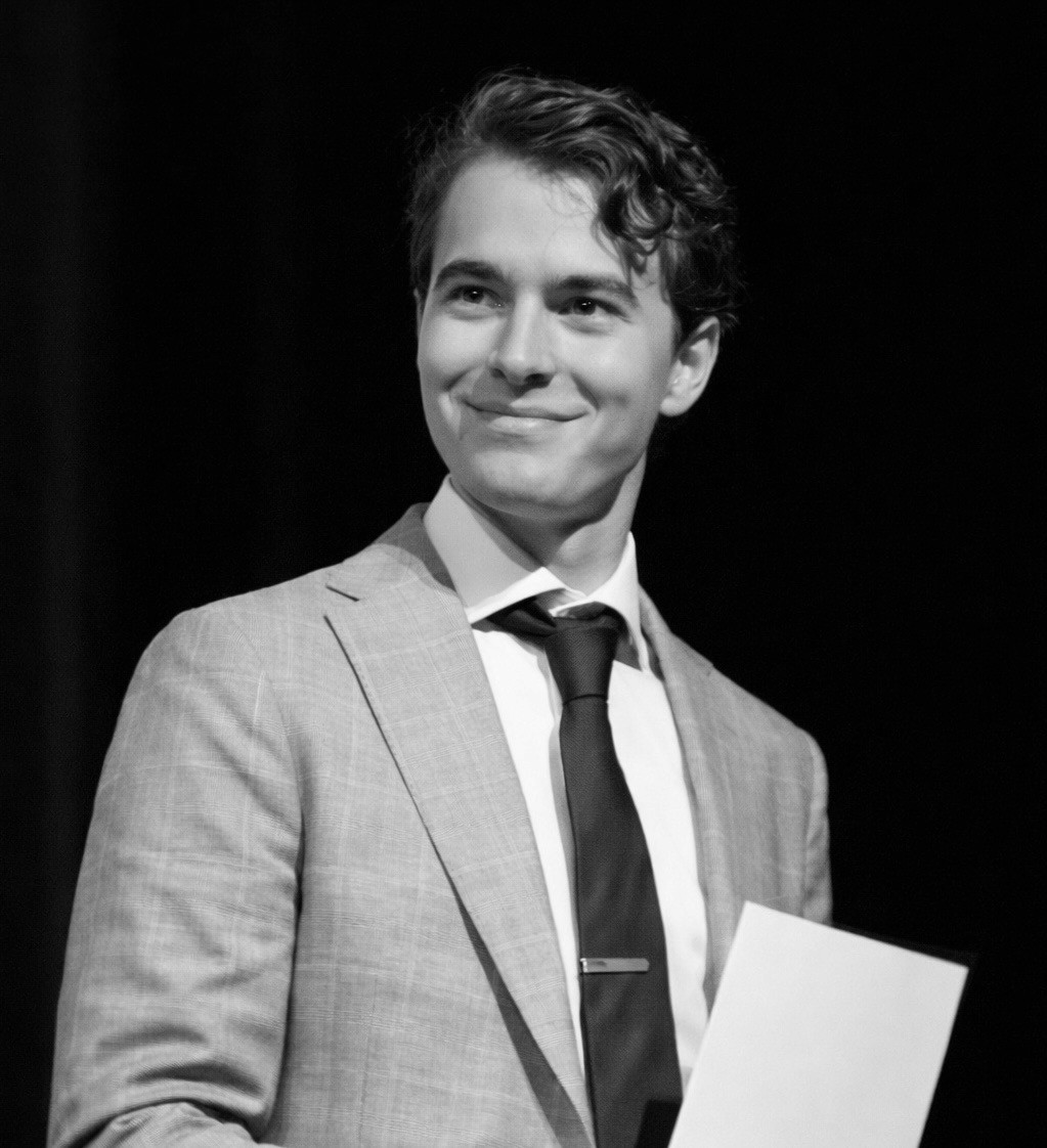 Portrait of a person in dark clothing speaking on a phone