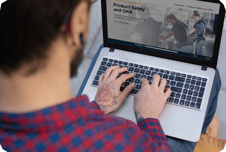 Male on his desk doing a bespoke e learning on his laptop