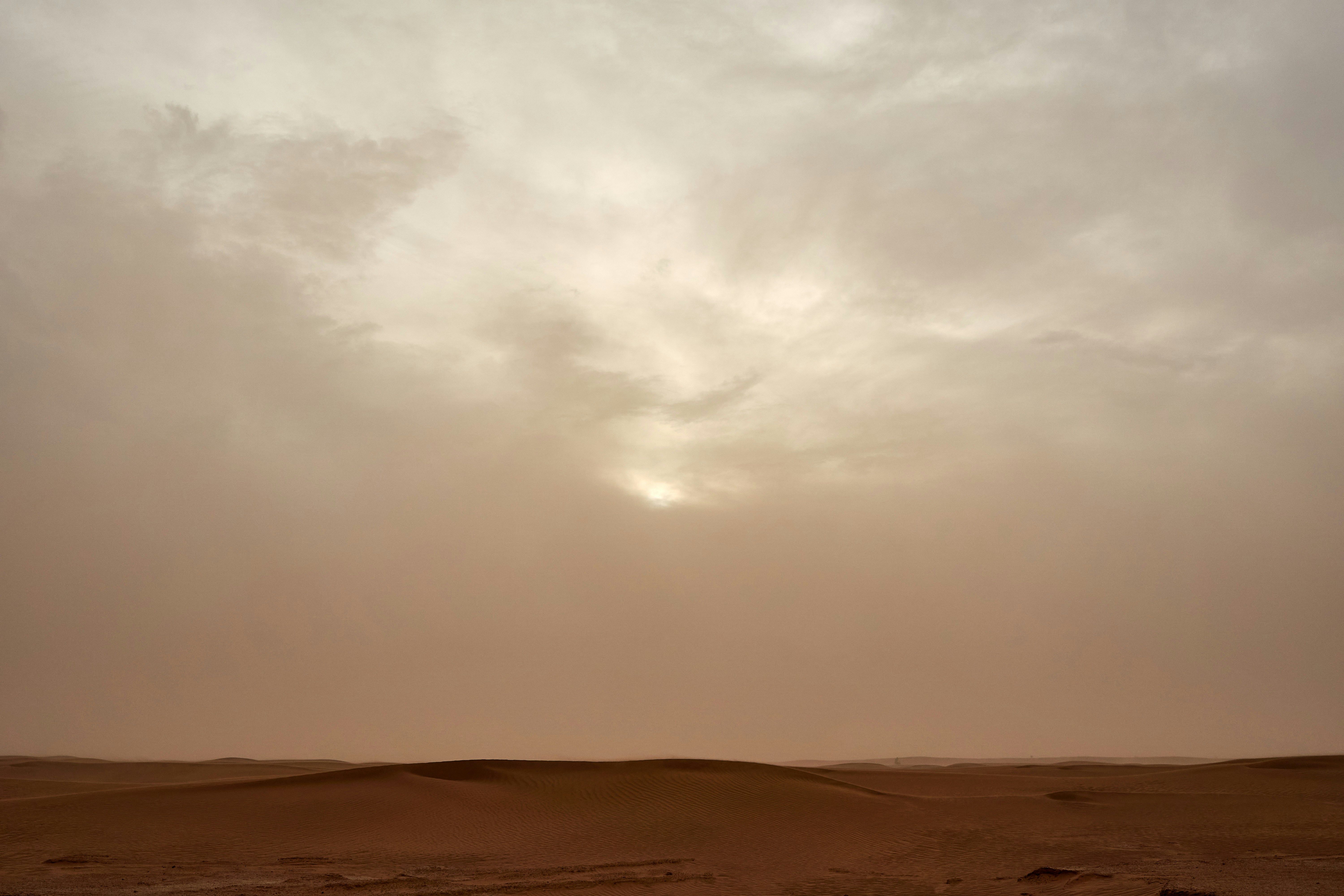 brown sand under white clouds