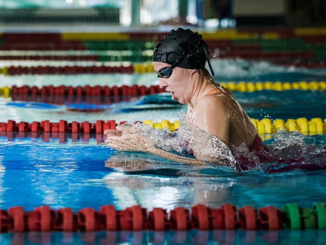 woman working out to lose weight by swimming by doing the breastsroke