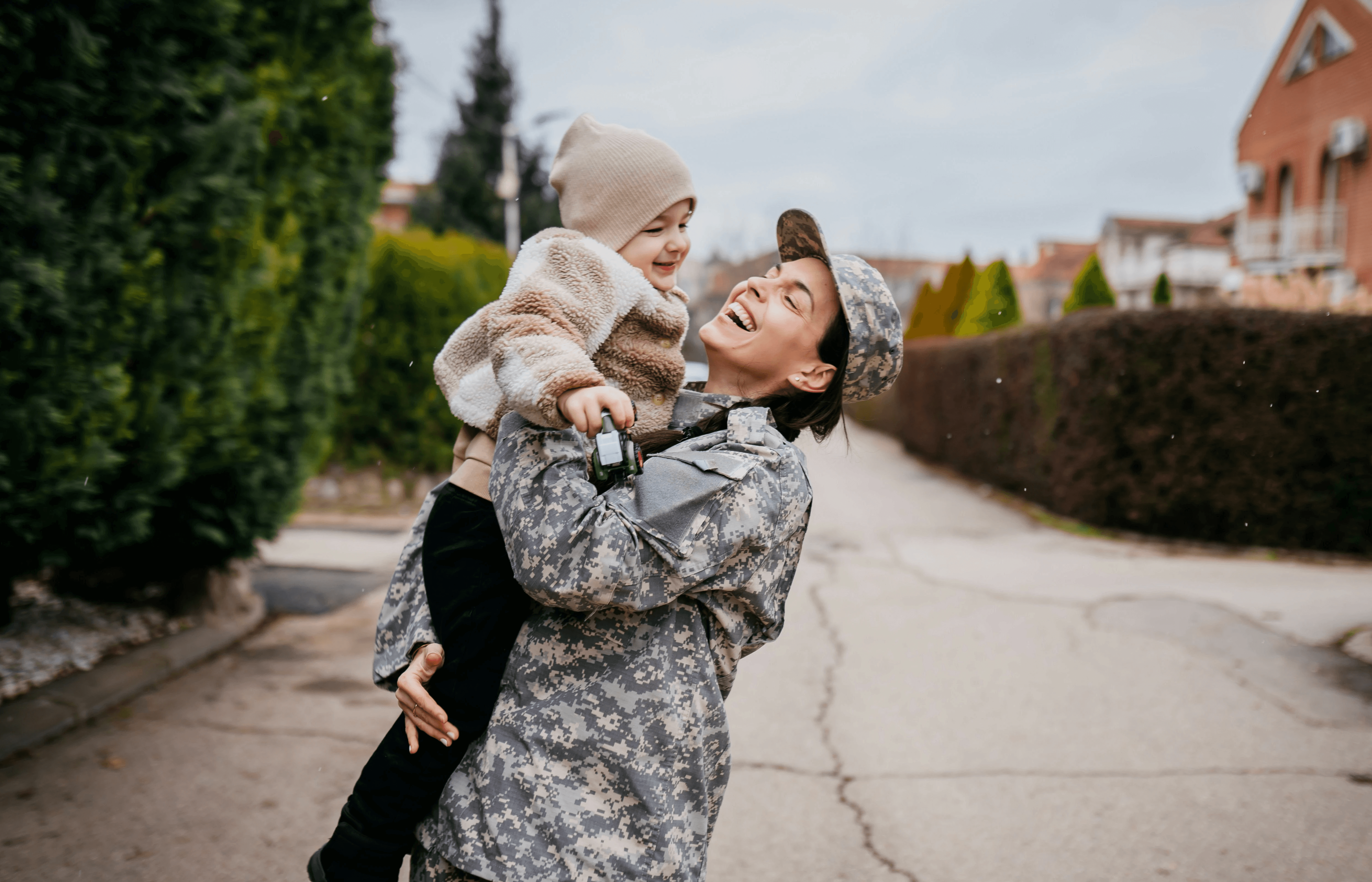 smiling servicewoman holding baby in street