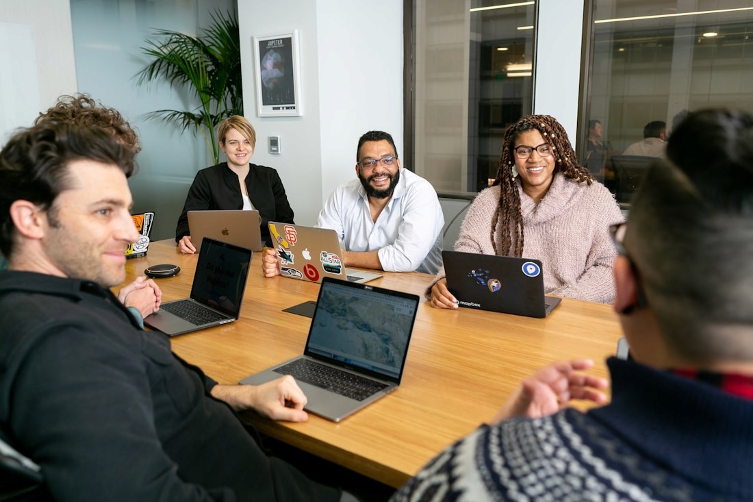 Team collaborating around a laptop in a bright office