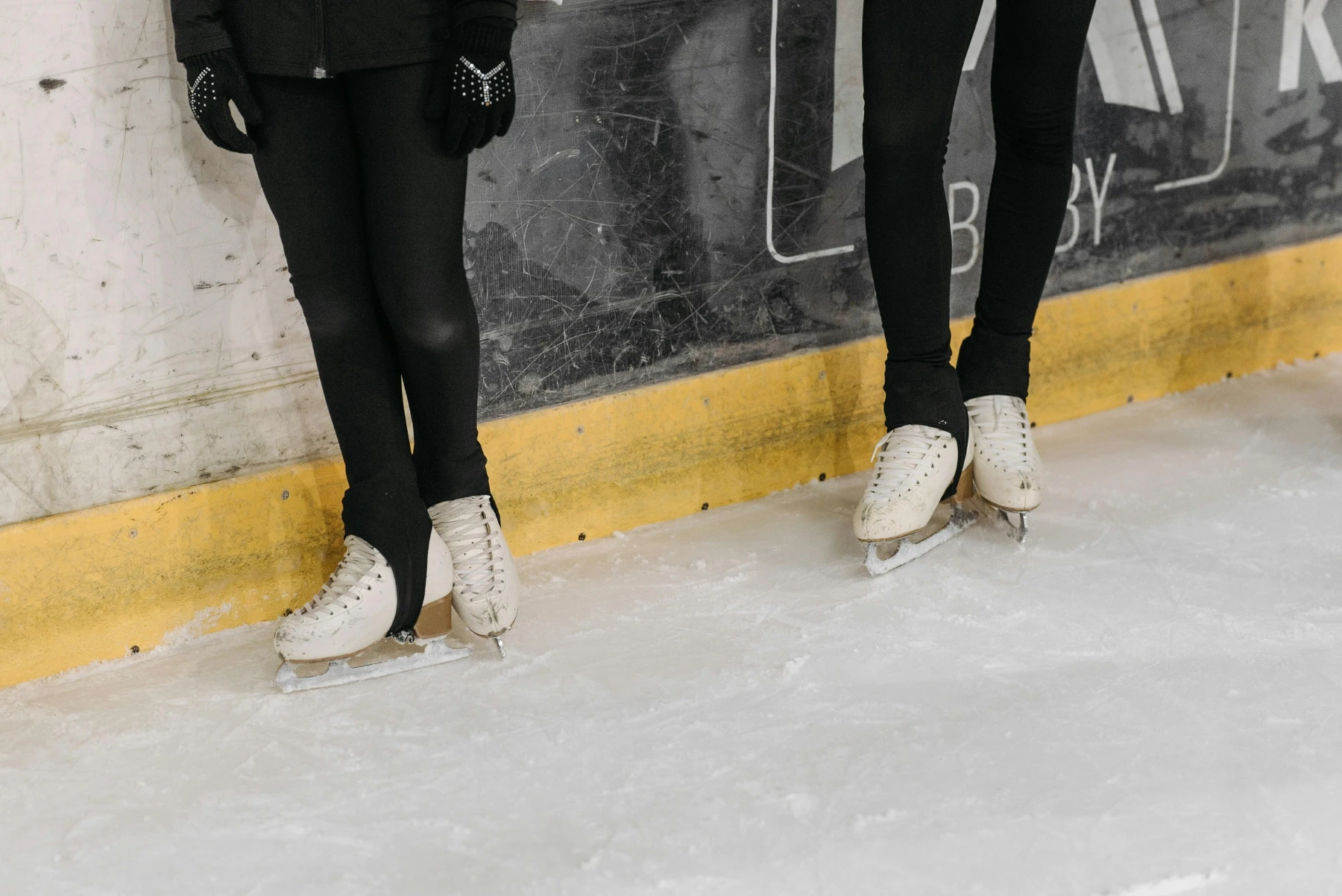 two people stood on the edge of a skating rink