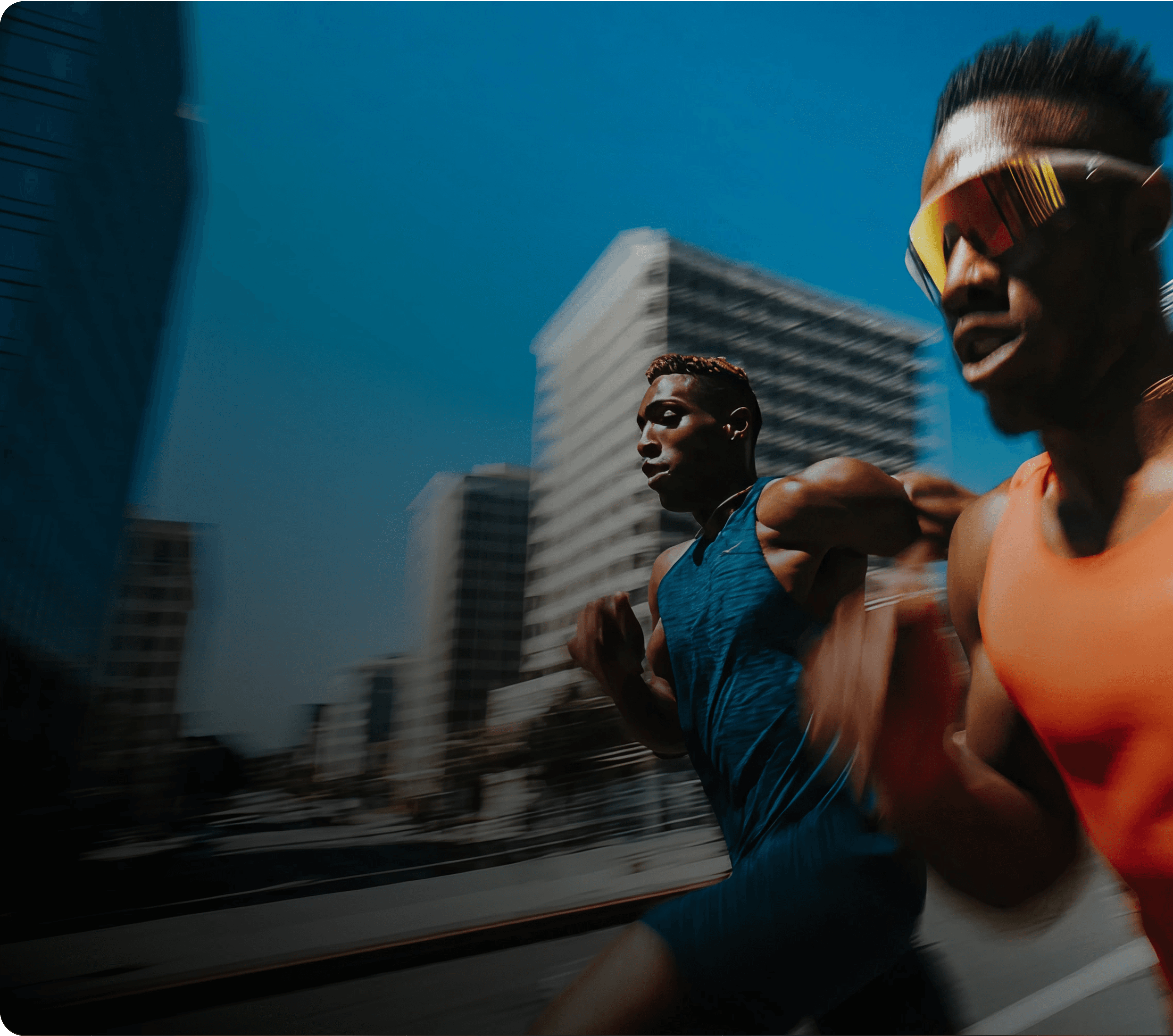 Two athletes sprinting outdoors in an urban environment with buildings in the background