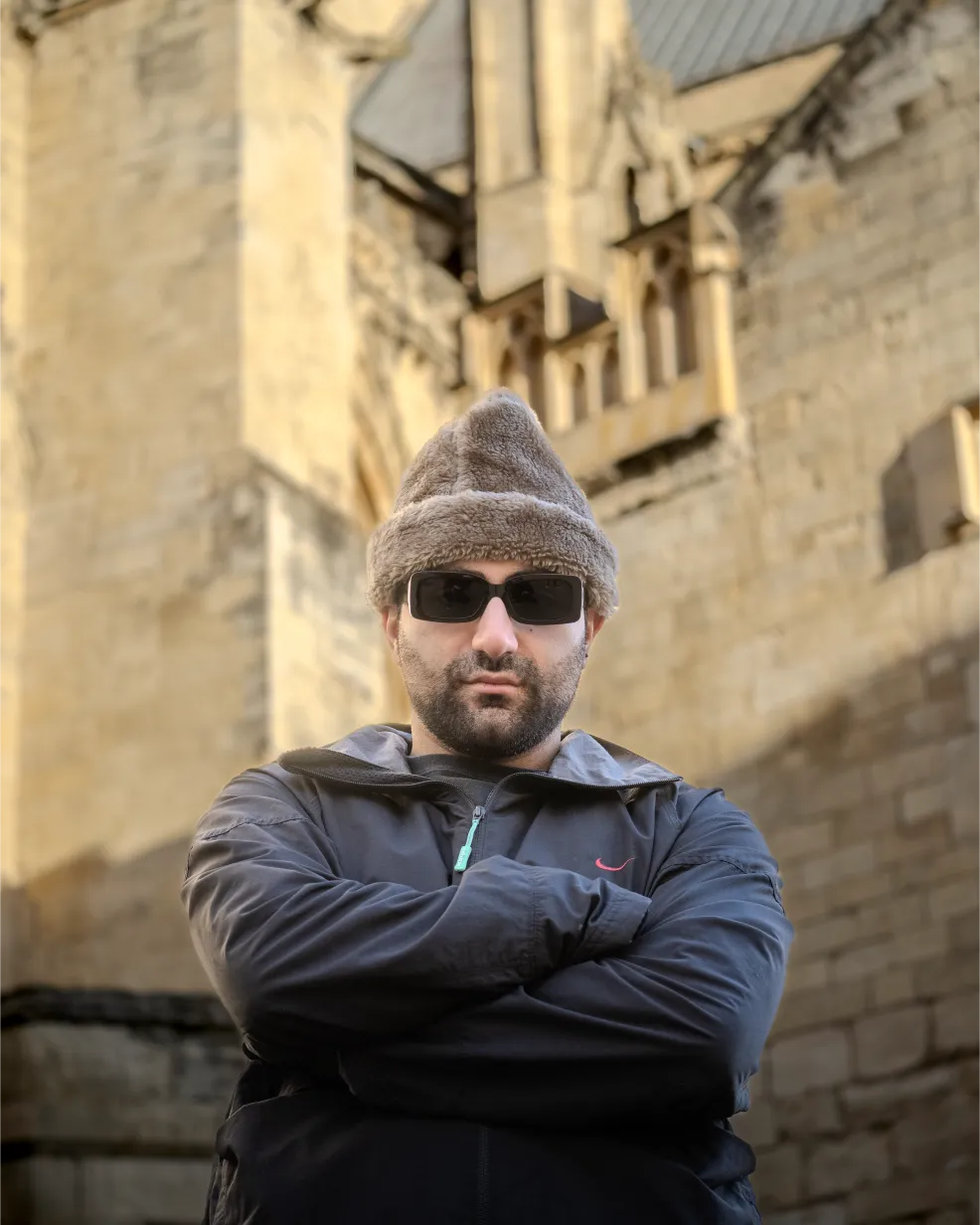 Aria standing with arms crossed in front of York Minster, capturing the texture of the historic stone and the modern streetwear styling.