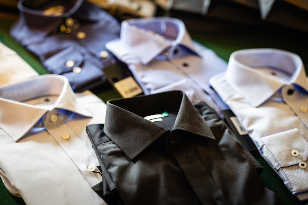 Närbild på uppvikta skjortor och slipsar, exempel på premium profilkläder.