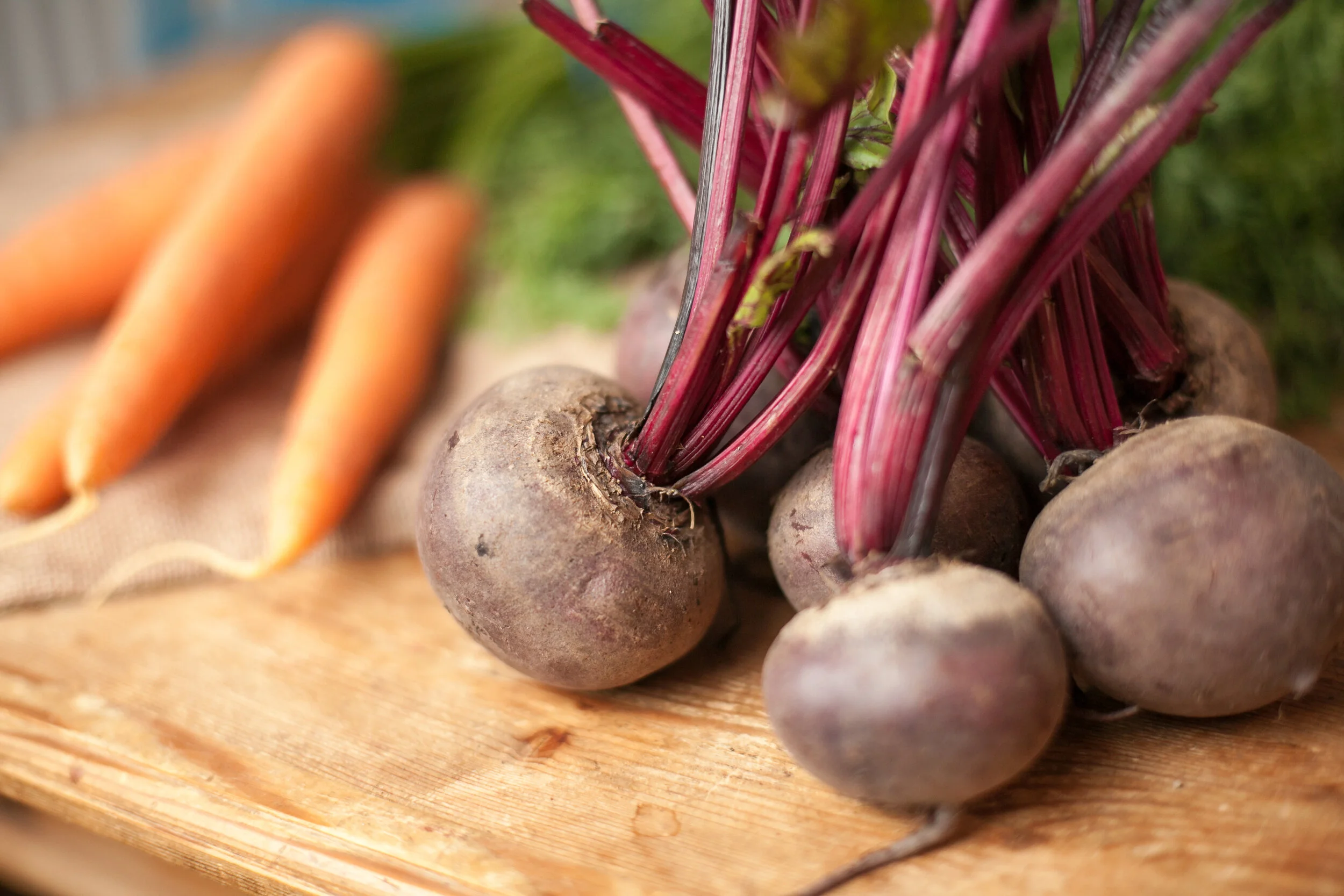 Raw carrots and beetroot on chopping board