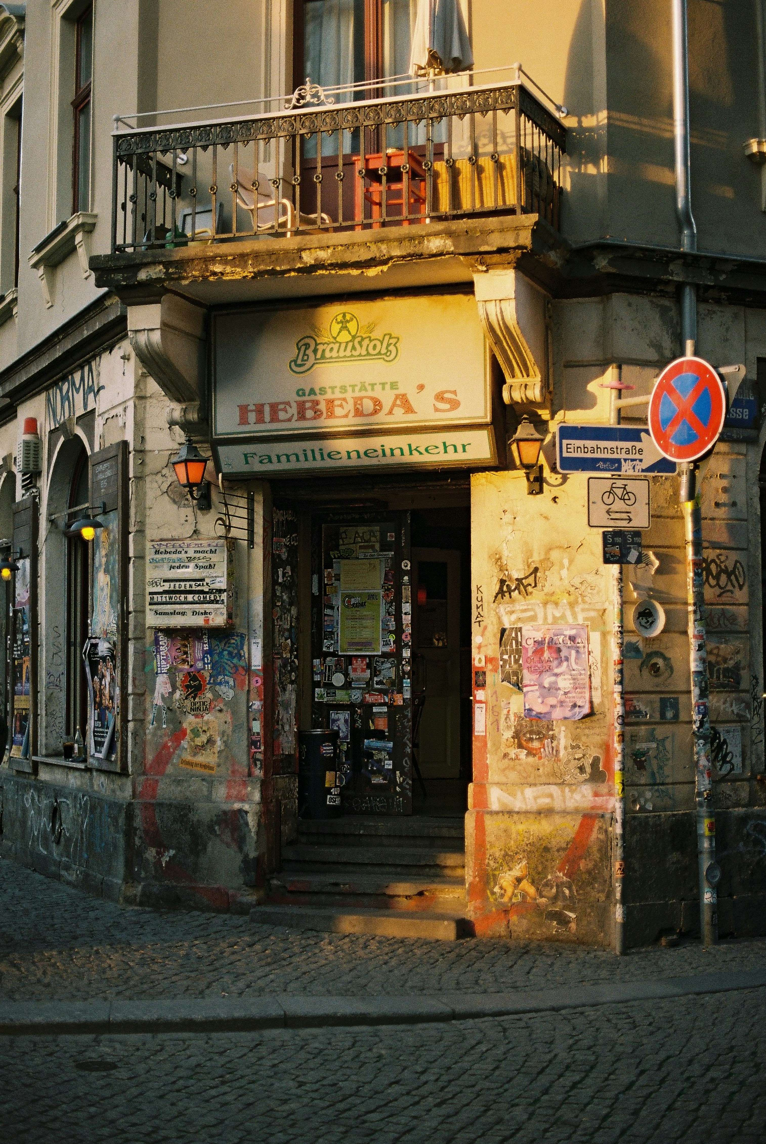 Corner building entrance covered in graffiti and posters.