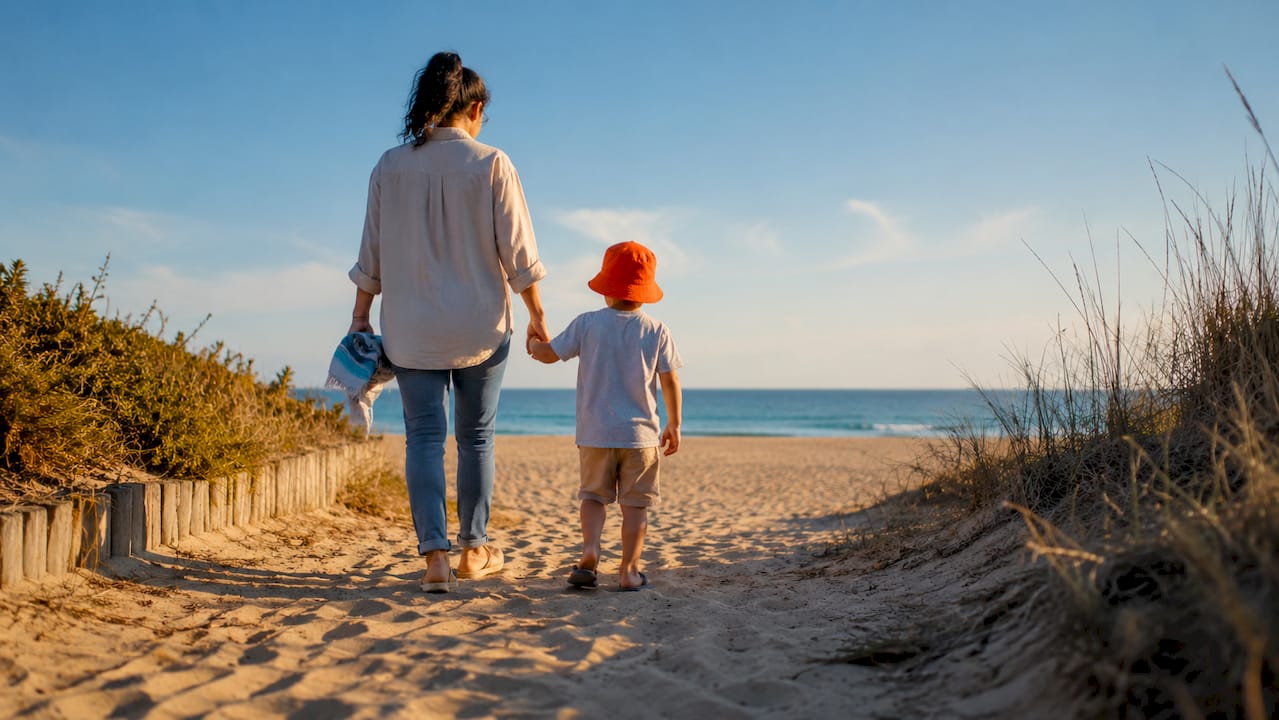 Family walking toward a calm beach outing